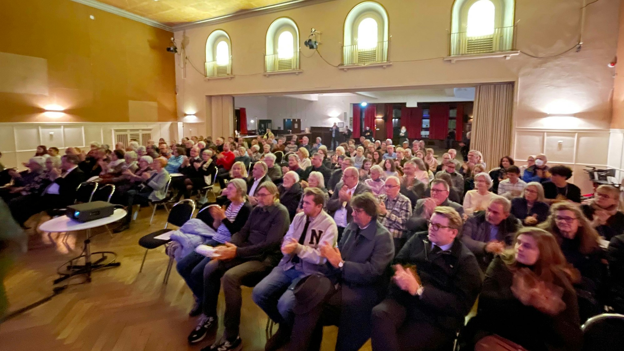 Ein Blick in den Saal des Casinos, in dem das Publikum in Stuhlreihen sitzt.