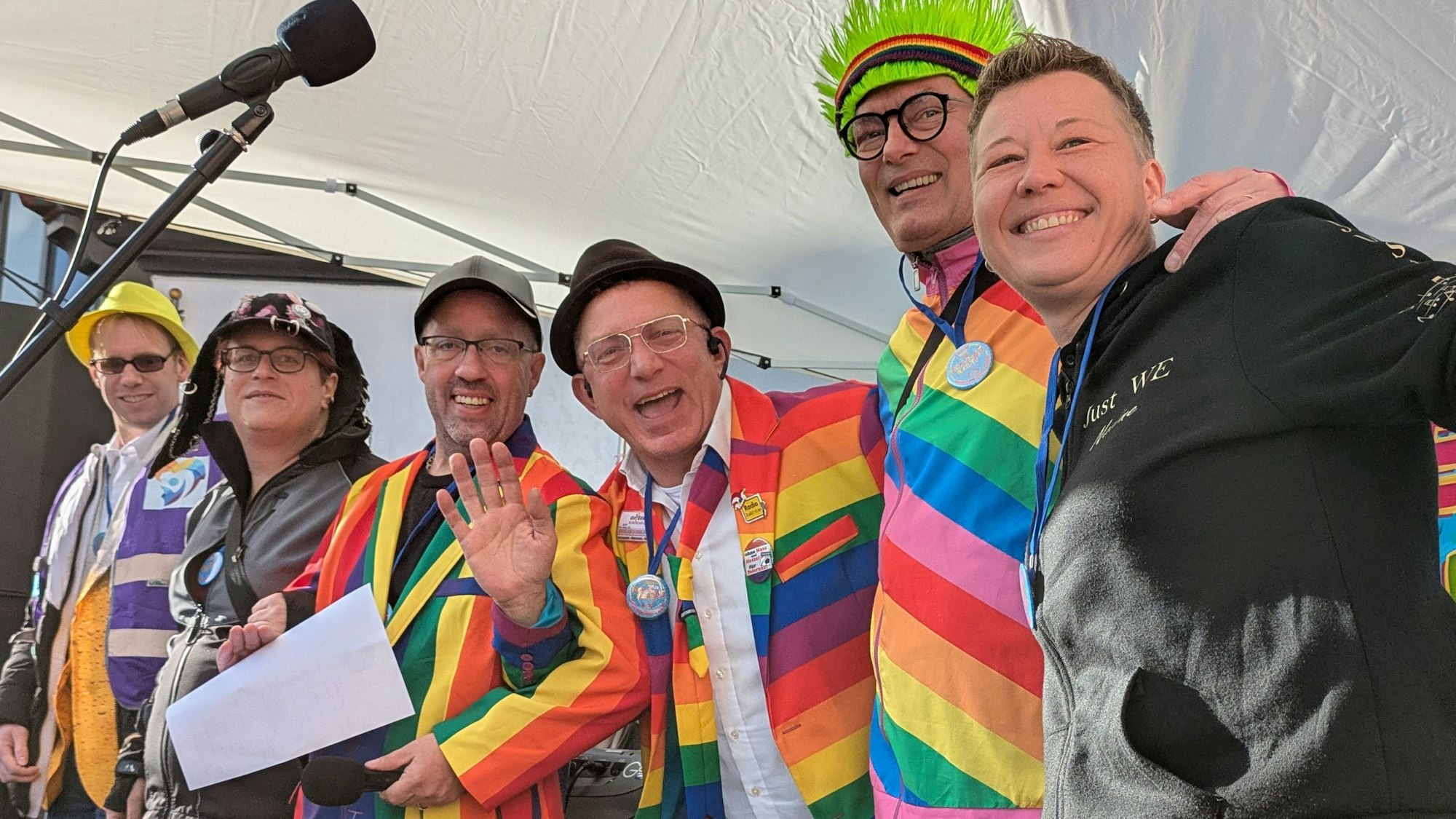 Sechs karnevalistisch verkleidete Menschen schunkeln.