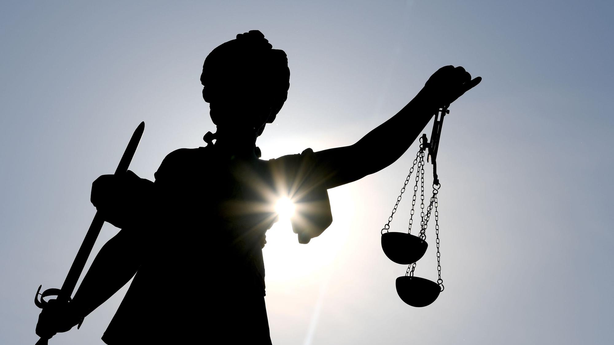 Die Göttin Justitia im Gegenlicht auf dem Gerechtigkeitsbrunnen in Frankfurt am Main.
