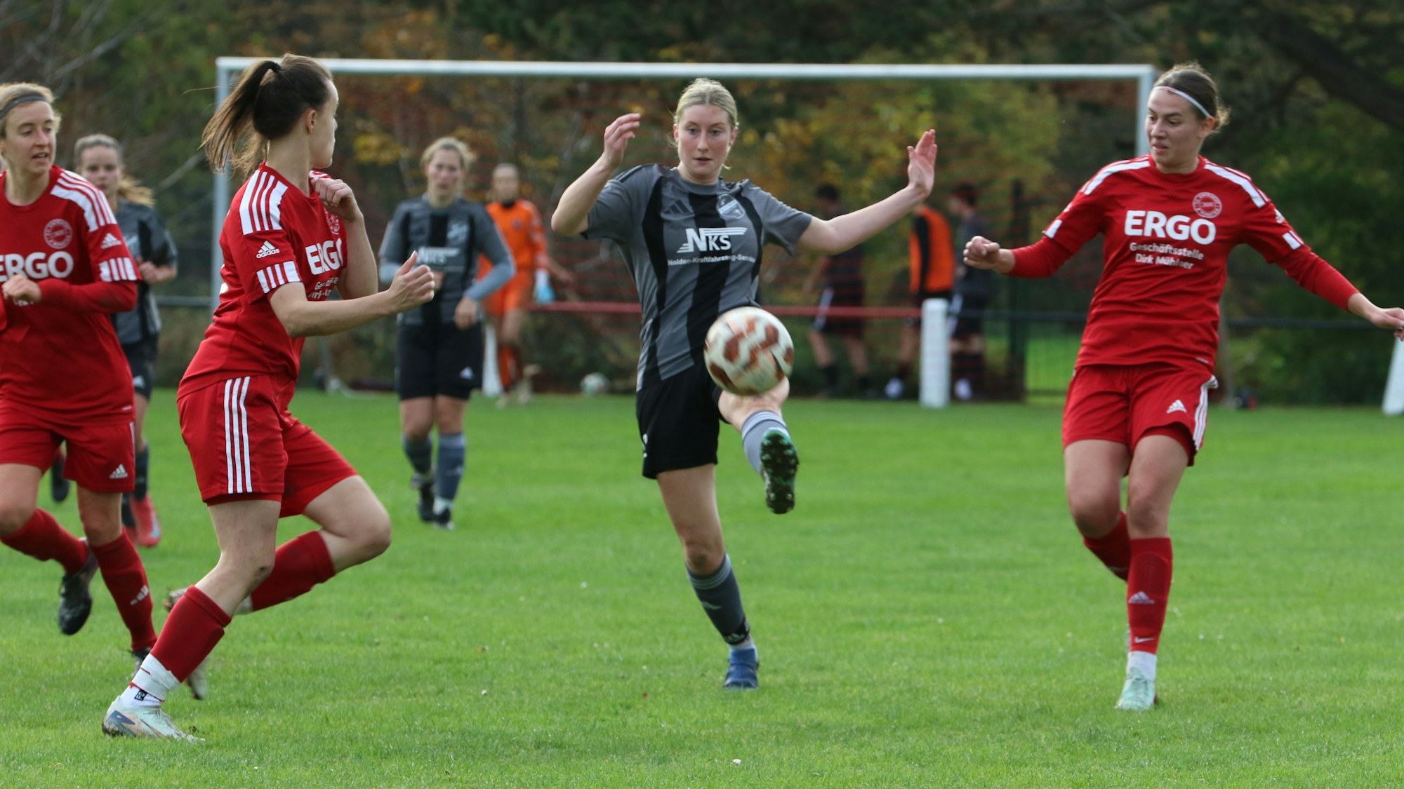 Anne Drehsen nimmt den Ball mit ausgestrecktem Fuß an. Von beiden Seiten nähern sich Gegenspielerinnen.