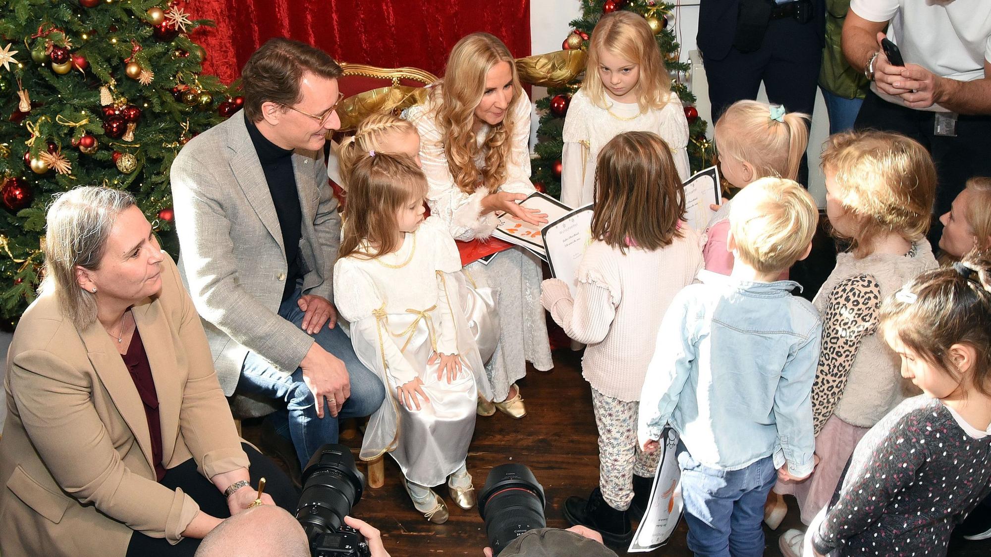 Kindergartenkinder stehen in einer Schlange, um ihre Wunschzettel abzugeben.
