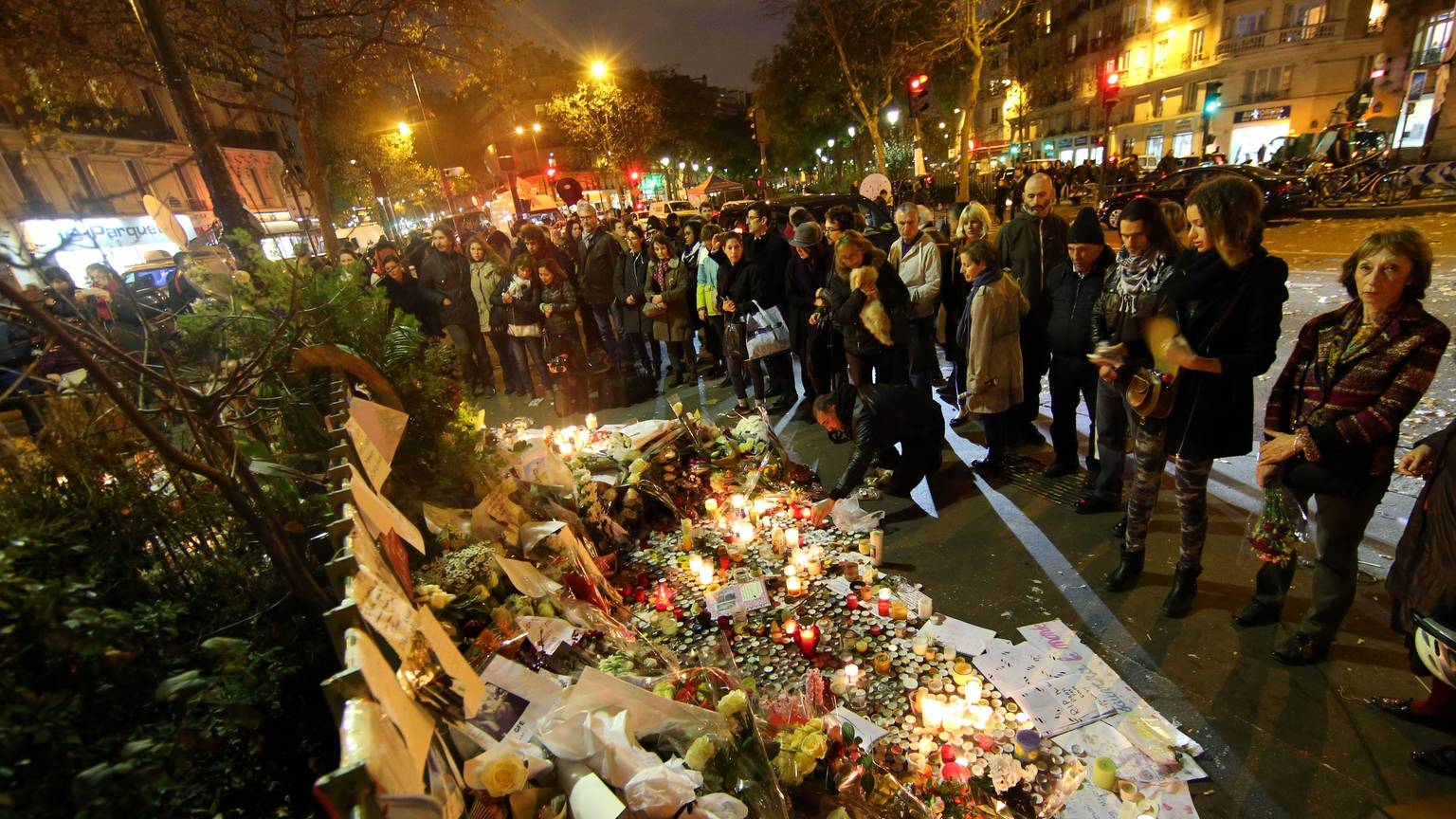 Paris: Trauernde Menschen zünden am 16.11.2015 vor dem Bataclan Theater in Paris (Frankreich) Kerzen an und legen Blumen nieder.