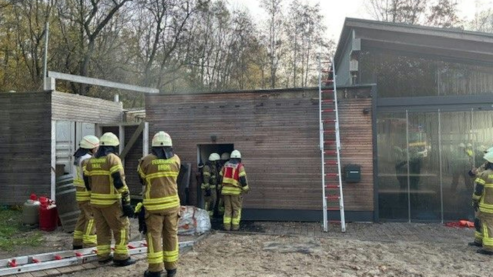 Das Bild zeigt Feuerwehrleute vor einem Strandpavillon.