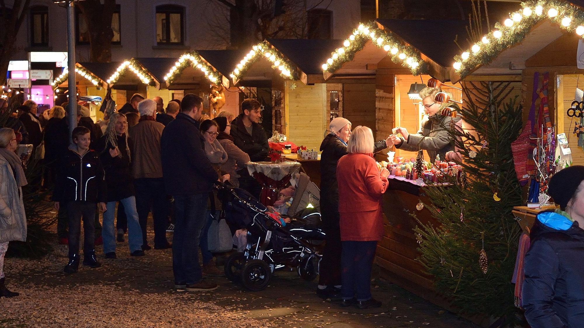 Buden stehen am Abend auf dem Overather Weihnachtsmarkt.