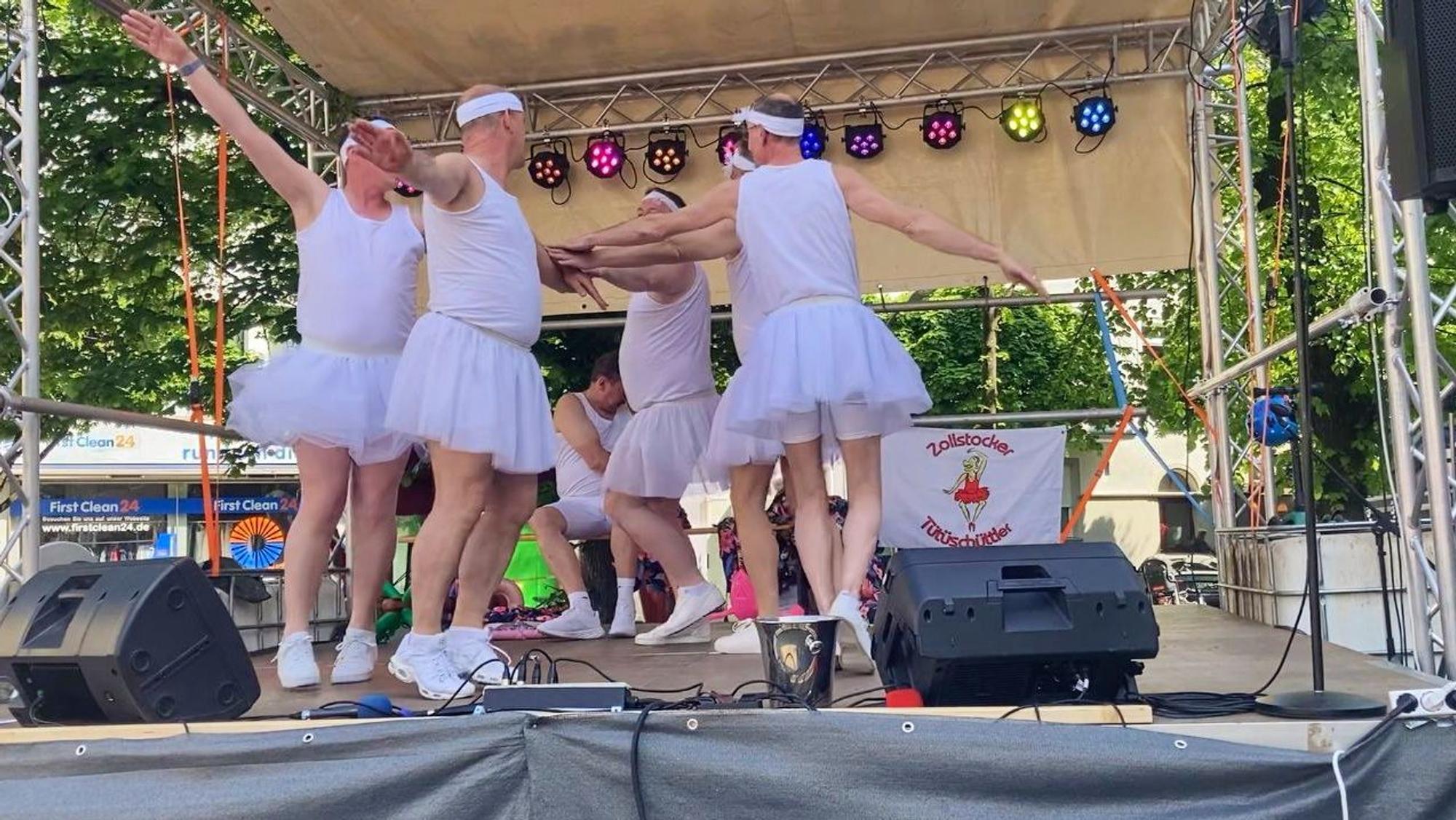Die Zollstocker Tütüschüttler als weiße Schwäne auf einem Straßenfest.