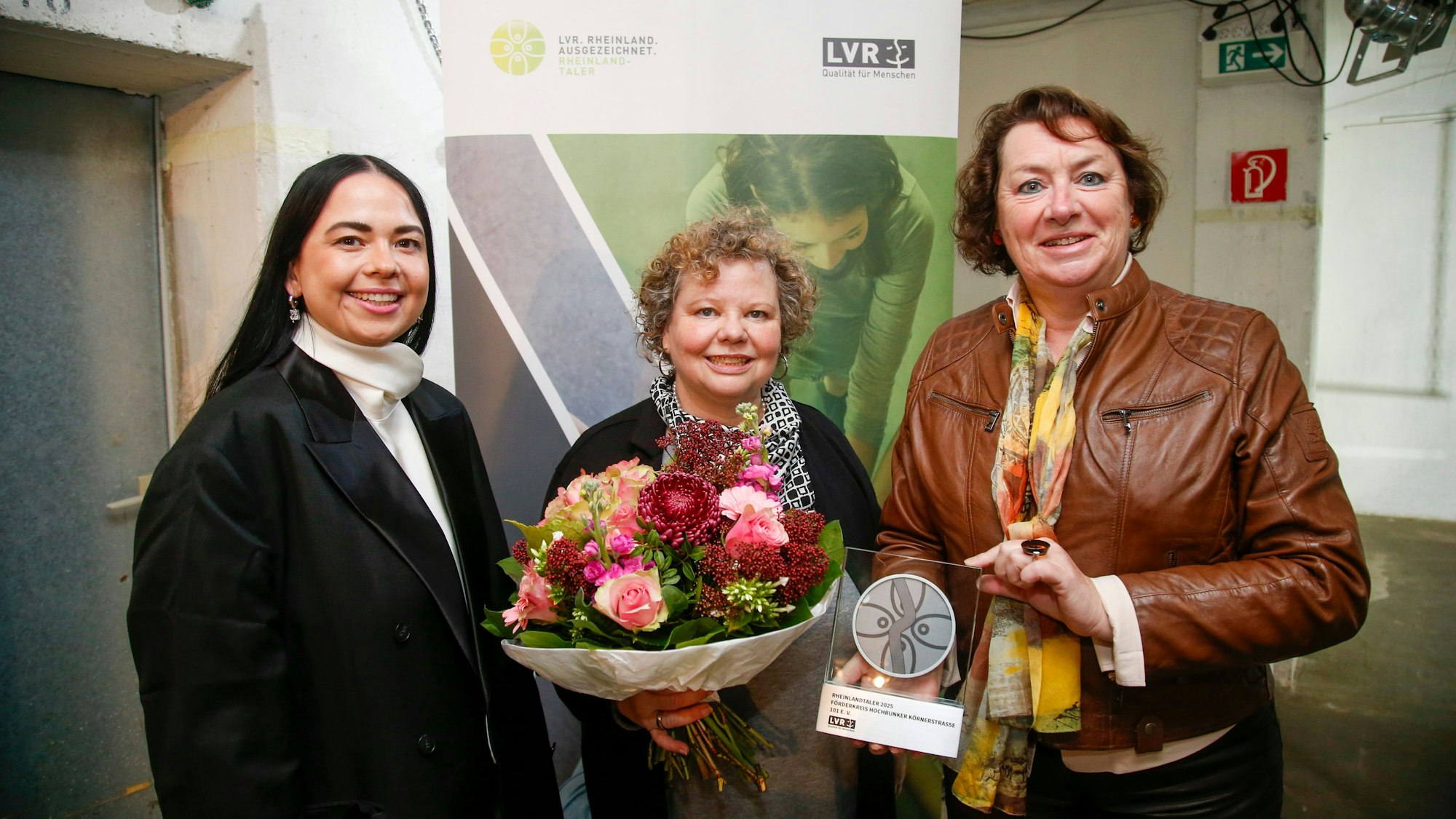 Anne Henk-Hollstein (r.) übergab Petra Bossinger (m.), 2. Vorsitzende des „Förderkreises Hochbunker Körnerstraße 101“, den Rheinlandtaler.