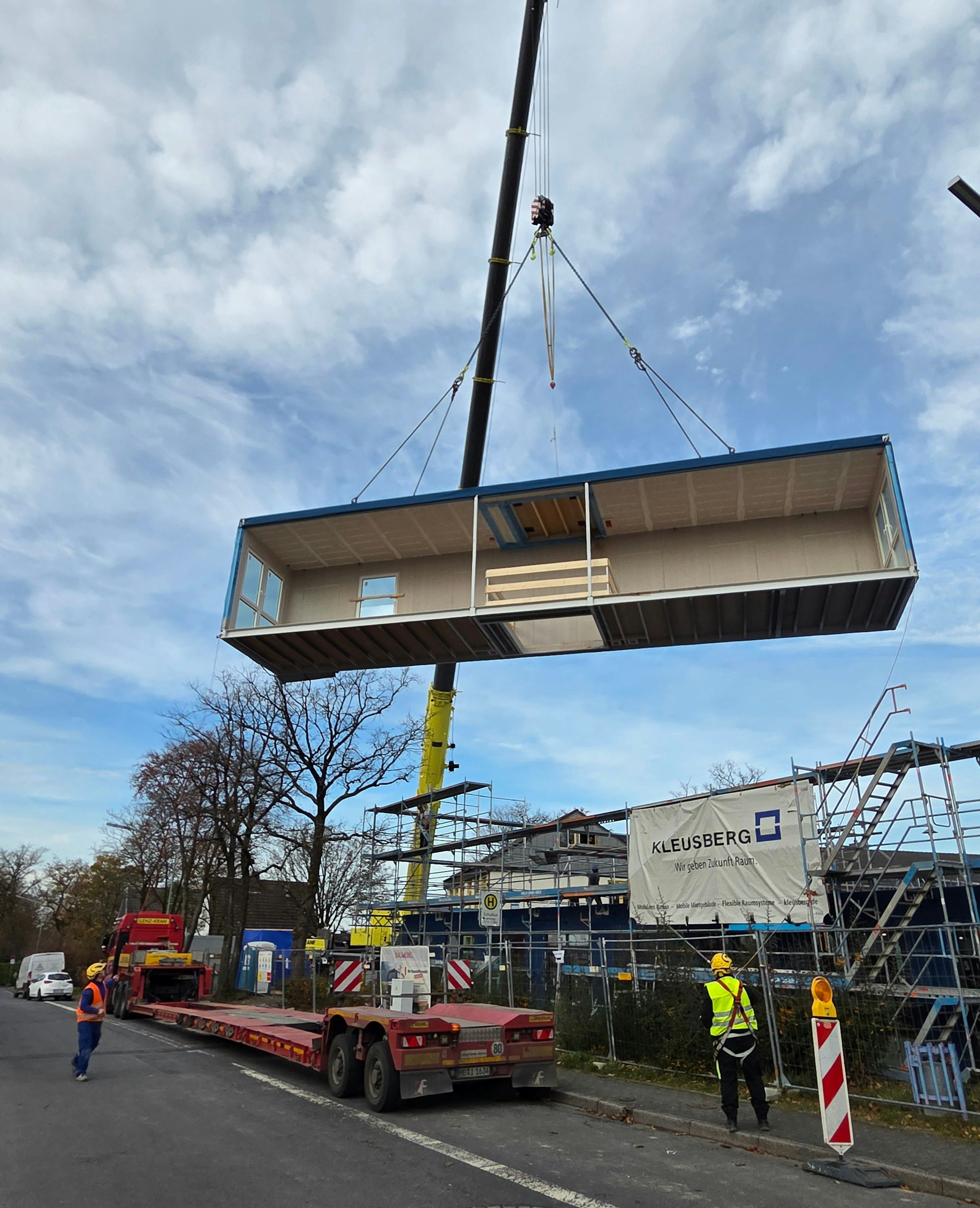 Ein Spezialkran hievt am Karl-Conrad-Weg im Waldbröler Stadtteil Isengarten ein Raummodul vom Schwerlasttransporter auf das Erdgeschoss des neuen Schulgebäudes.