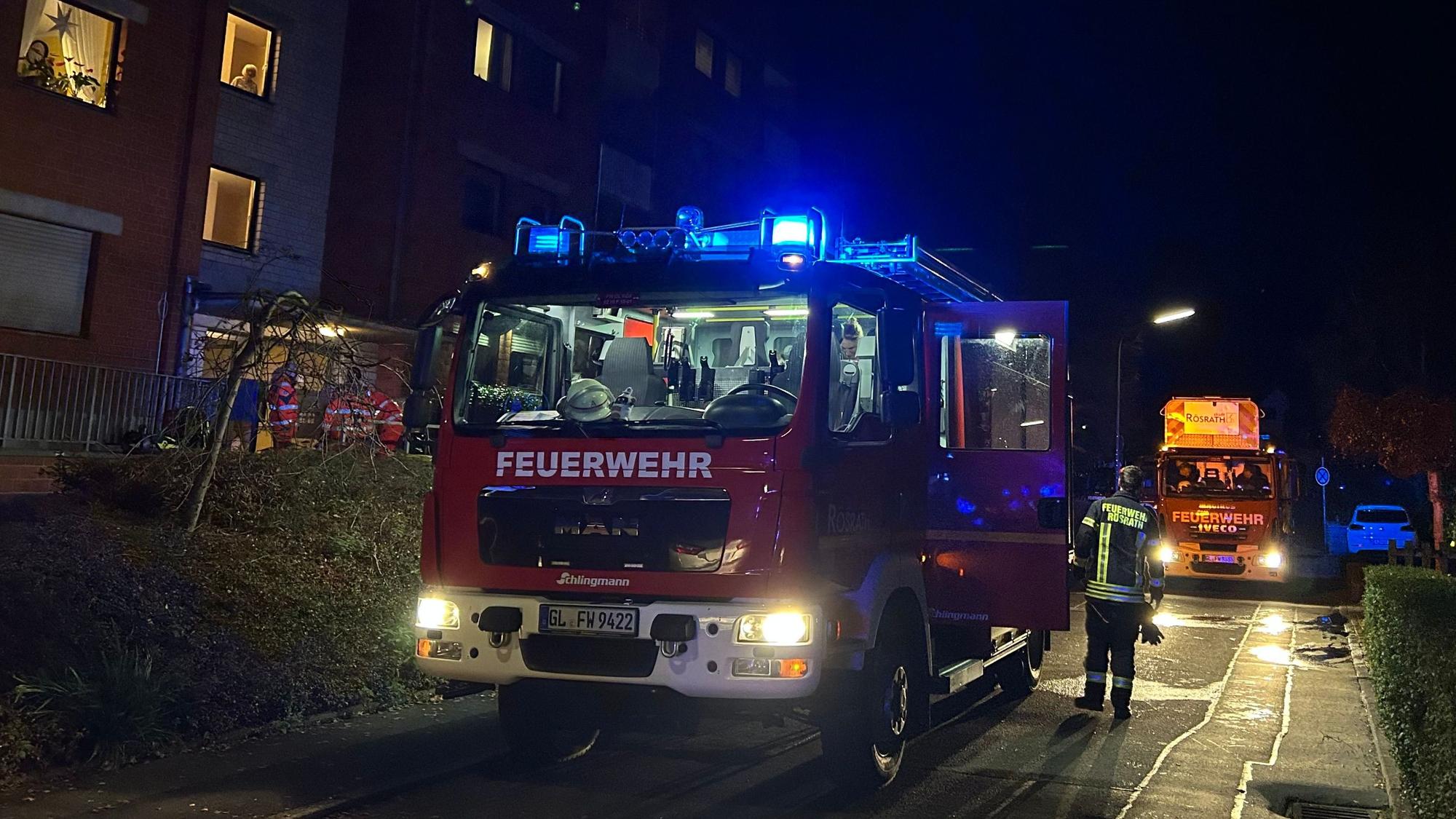 Feuerwehrfahrzeuge mit Blaulicht stehen vor einem Mehrfamilienhaus an der Gartenstraße in Rösrath-Hoffnungsthal.