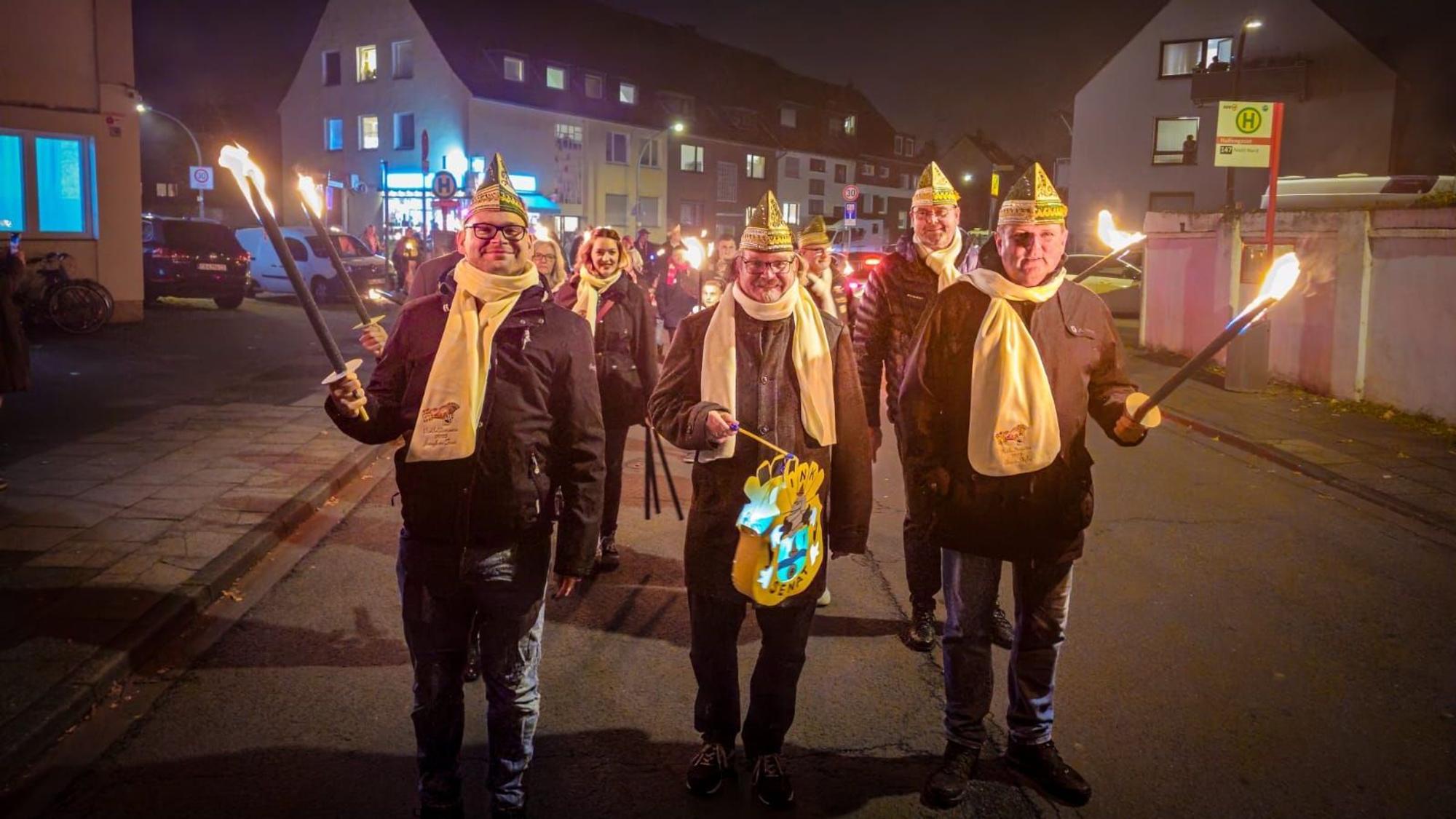 Das designierte Niehler Dreigestirn aus Jungfrau Tinni, Prinz Greger I. und Bauer Stefan (v.l.) an der Spitze des Fackelzugs vom CfB-Clubheim zum Schützenhof.