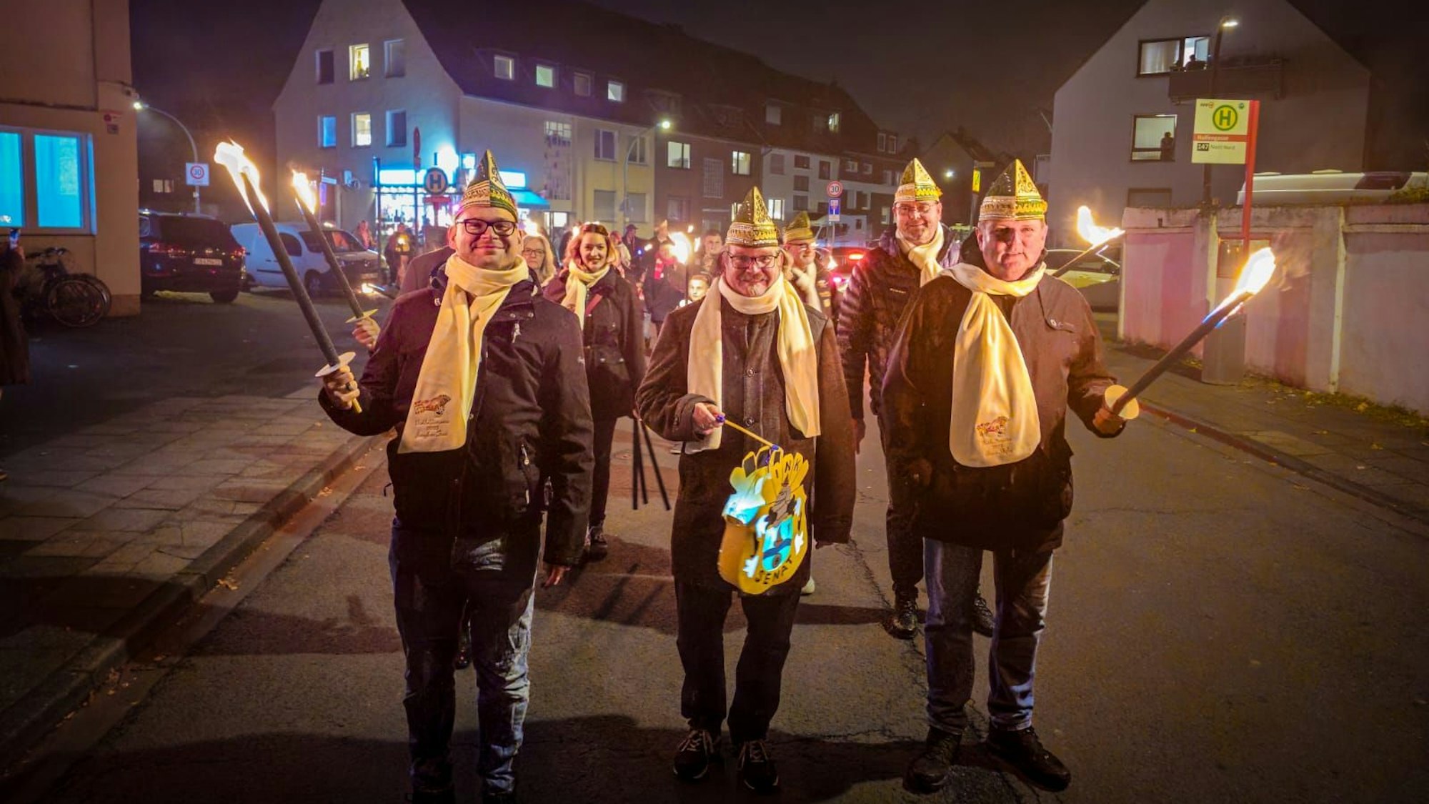 Das designierte Niehler Dreigestirn aus Jungfrau Tinni, Prinz Greger I. und Bauer Stefan (v.l.) an der Spitze des Fackelzugs vom CfB-Clubheim zum Schützenhof.