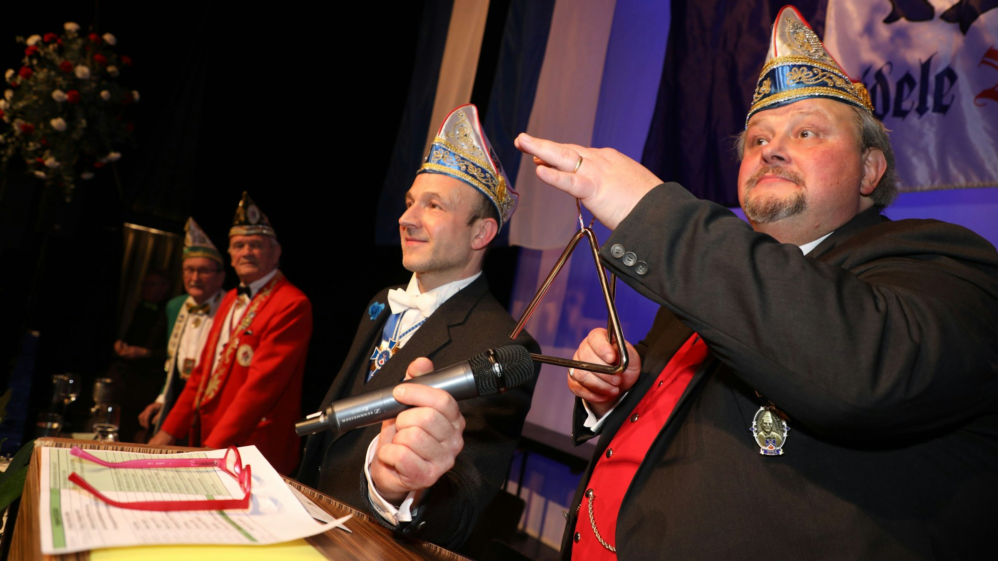 Thomas Cüpper schlägt als Sitzungspräsident der Sitzung Fastelovend Anno Pief eine Triangel an