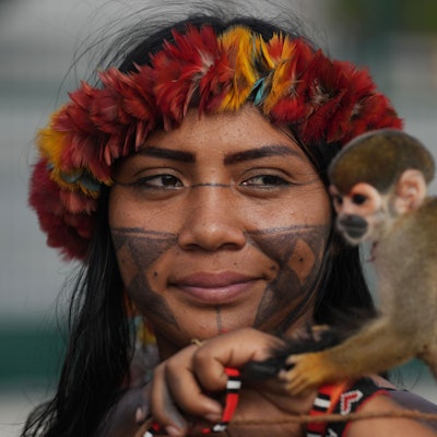 14.11.2025, Brasilien, Belem: Angelica Munduruku von der indigenen Gruppe der Munduruku hält einen Affen, als sie den Eingang zum COP30-Klimagipfel blockiert.
