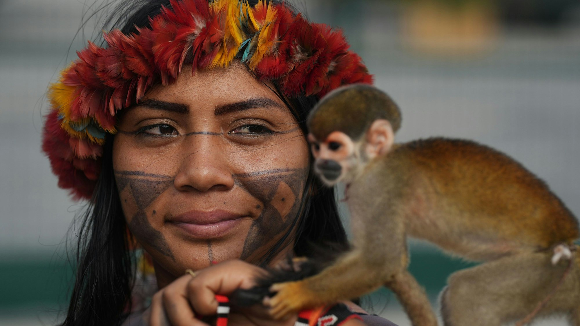 14.11.2025, Brasilien, Belem: Angelica Munduruku von der indigenen Gruppe der Munduruku hält einen Affen, als sie den Eingang zum COP30-Klimagipfel blockiert.