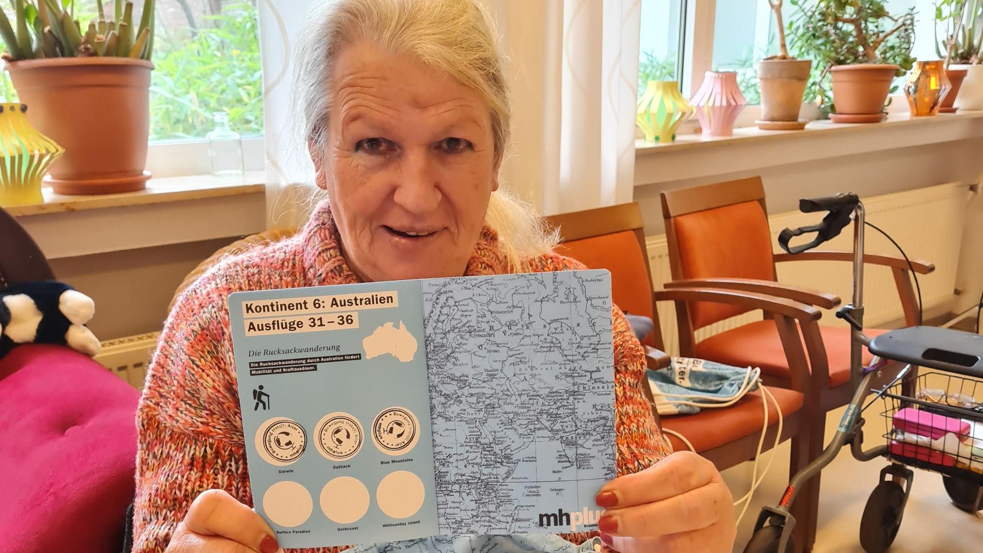 Eine Frau hält ein Heft mit Stempeln in die Kamera.