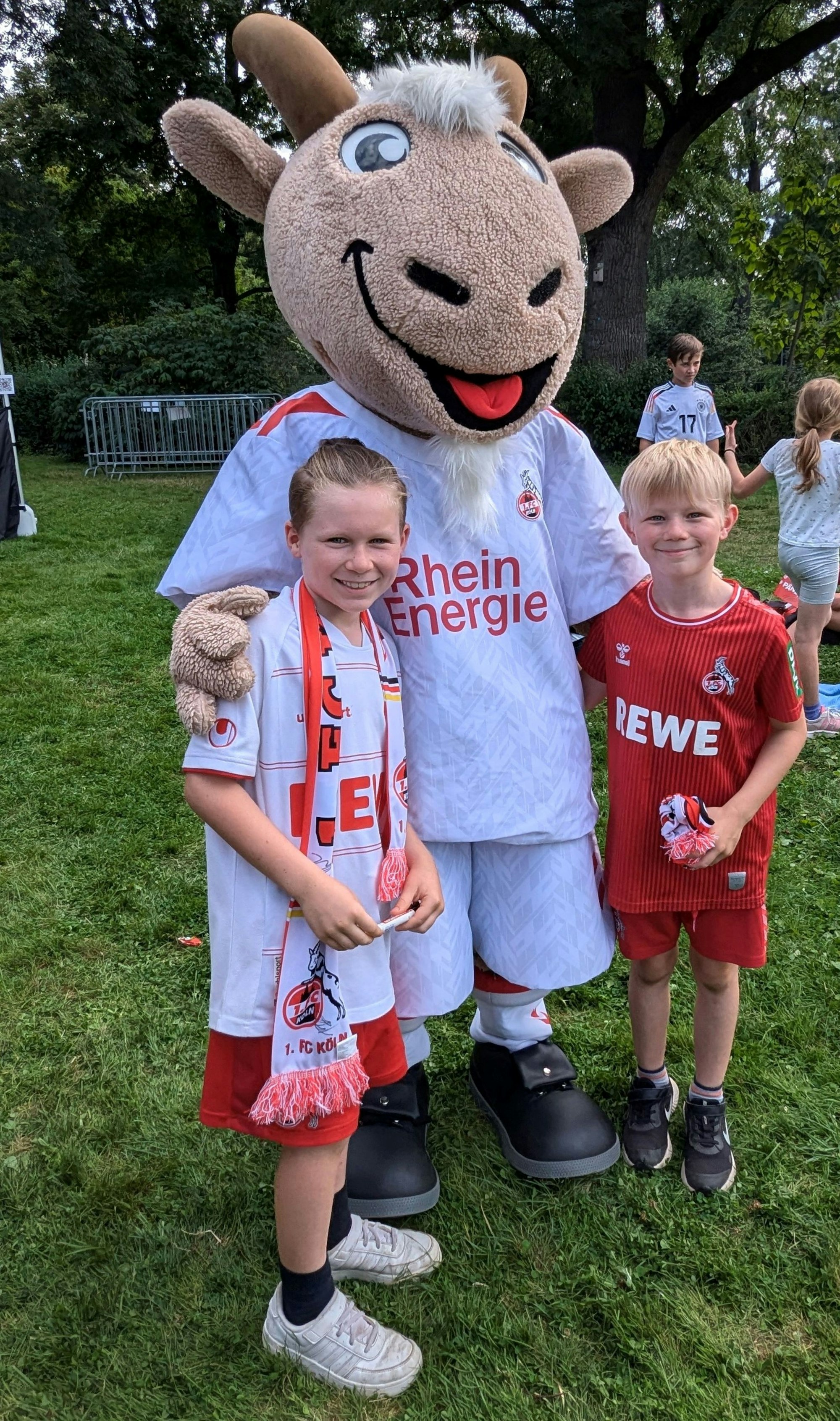 Zu sehen sind zwei Jungs mit dem Plüsch-Maskottchen des 1. FC Köln.