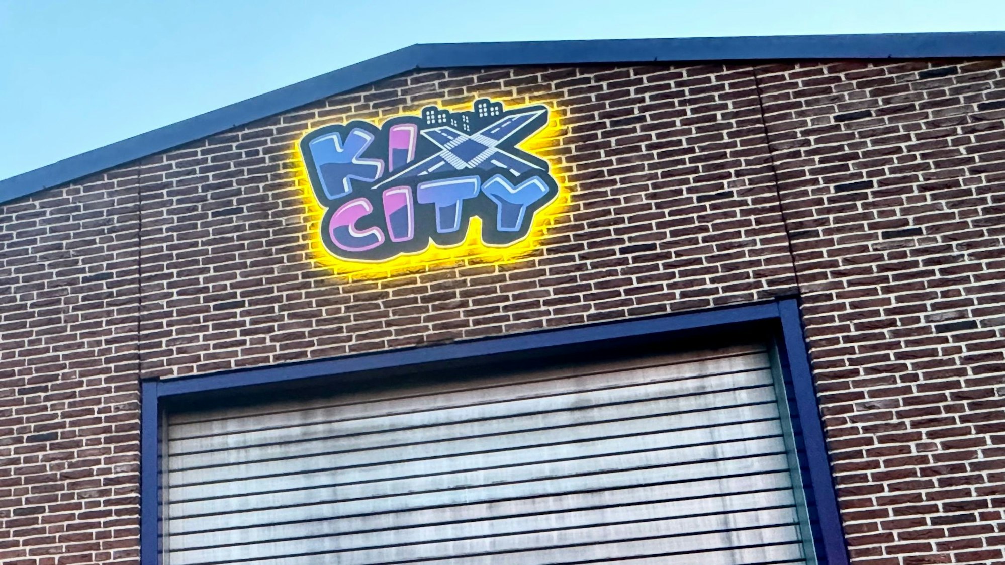 Zu sehen ist der Giebel eines Gewerbebaus mit dem Logo des neuen Unternehmens.