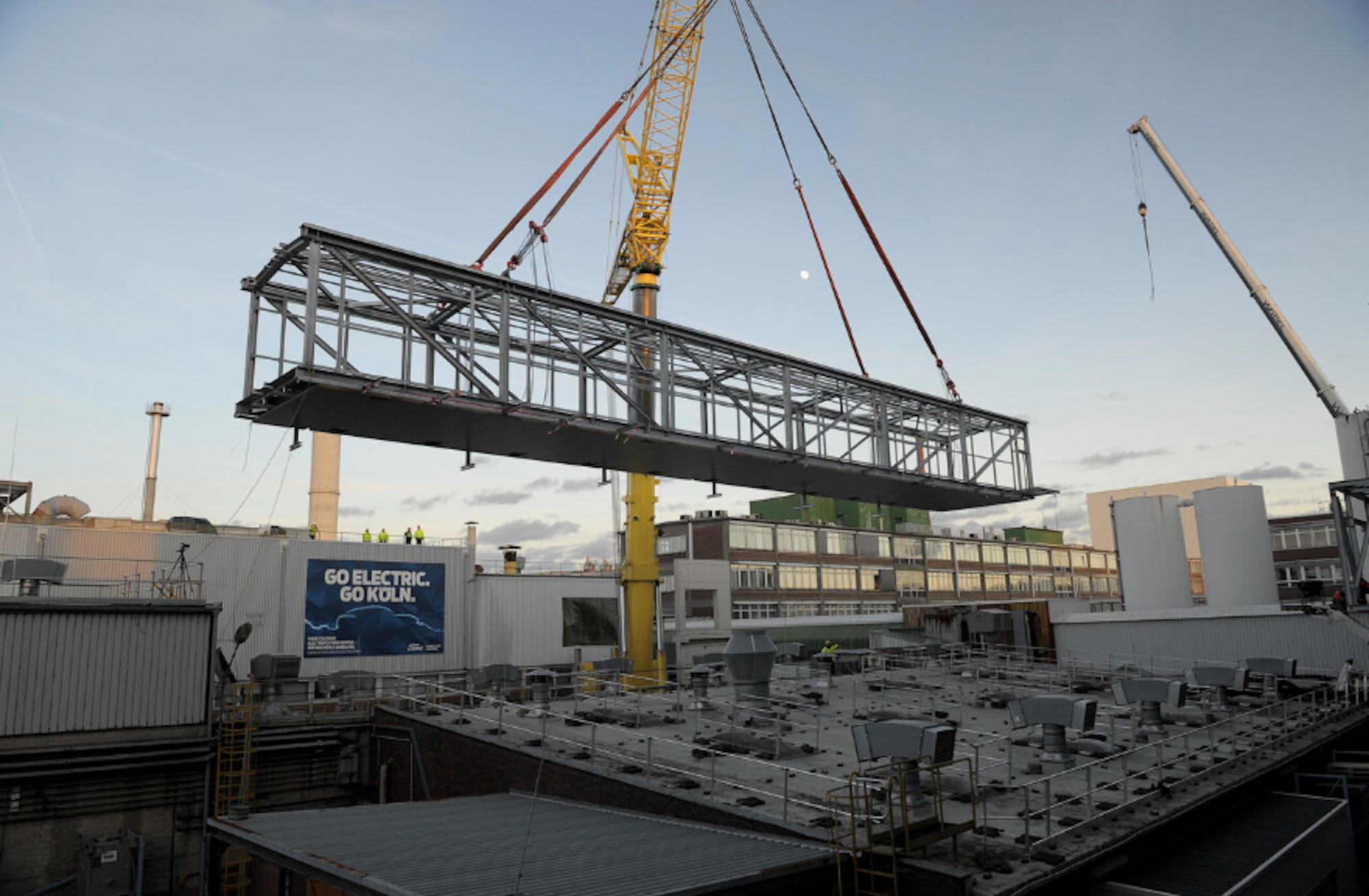 Umbau zum Ford Cologne Electric Vehicle Center: Ein 68 Tonnen schweres Teilstück einer Stahlbrücke wird im neu ausgerichteten Lackbereich installiert.