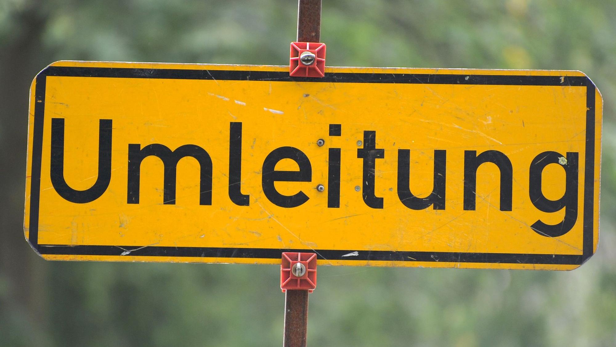 Auf einem gelben Schild steht das Wort „Umleitung“.