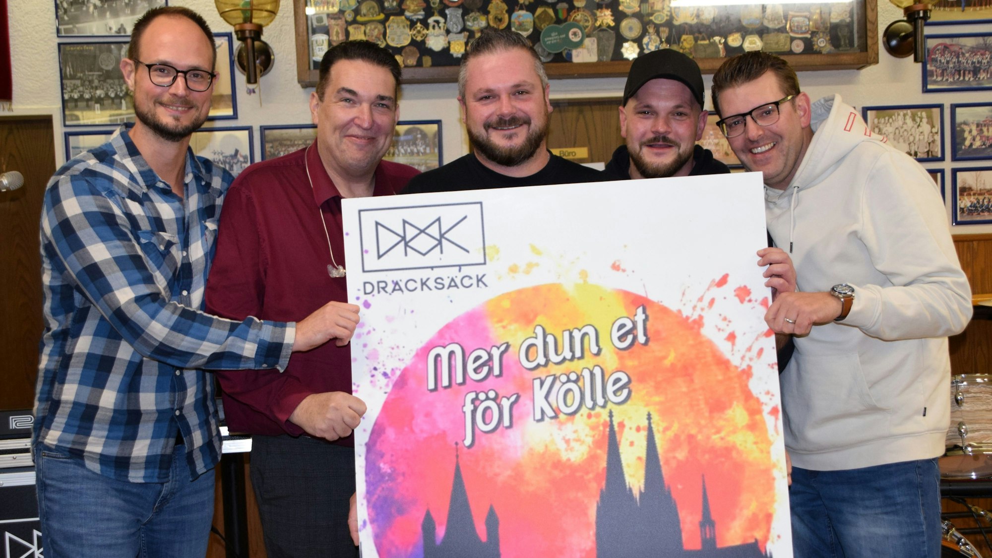 Fünf Männer halten ein Plakat mit