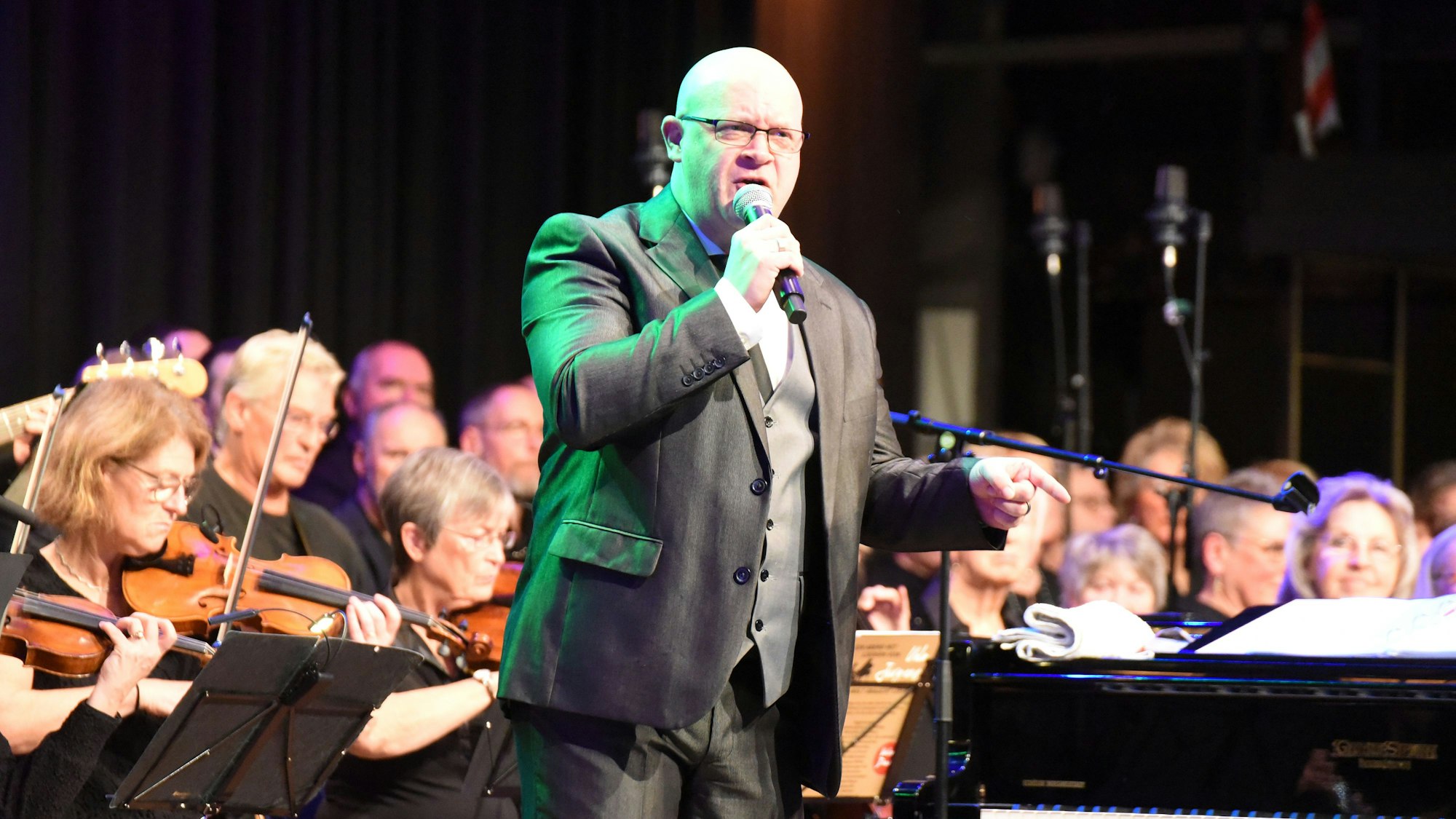Ein Gesangssolist vor Musikern und Chorsängern.
