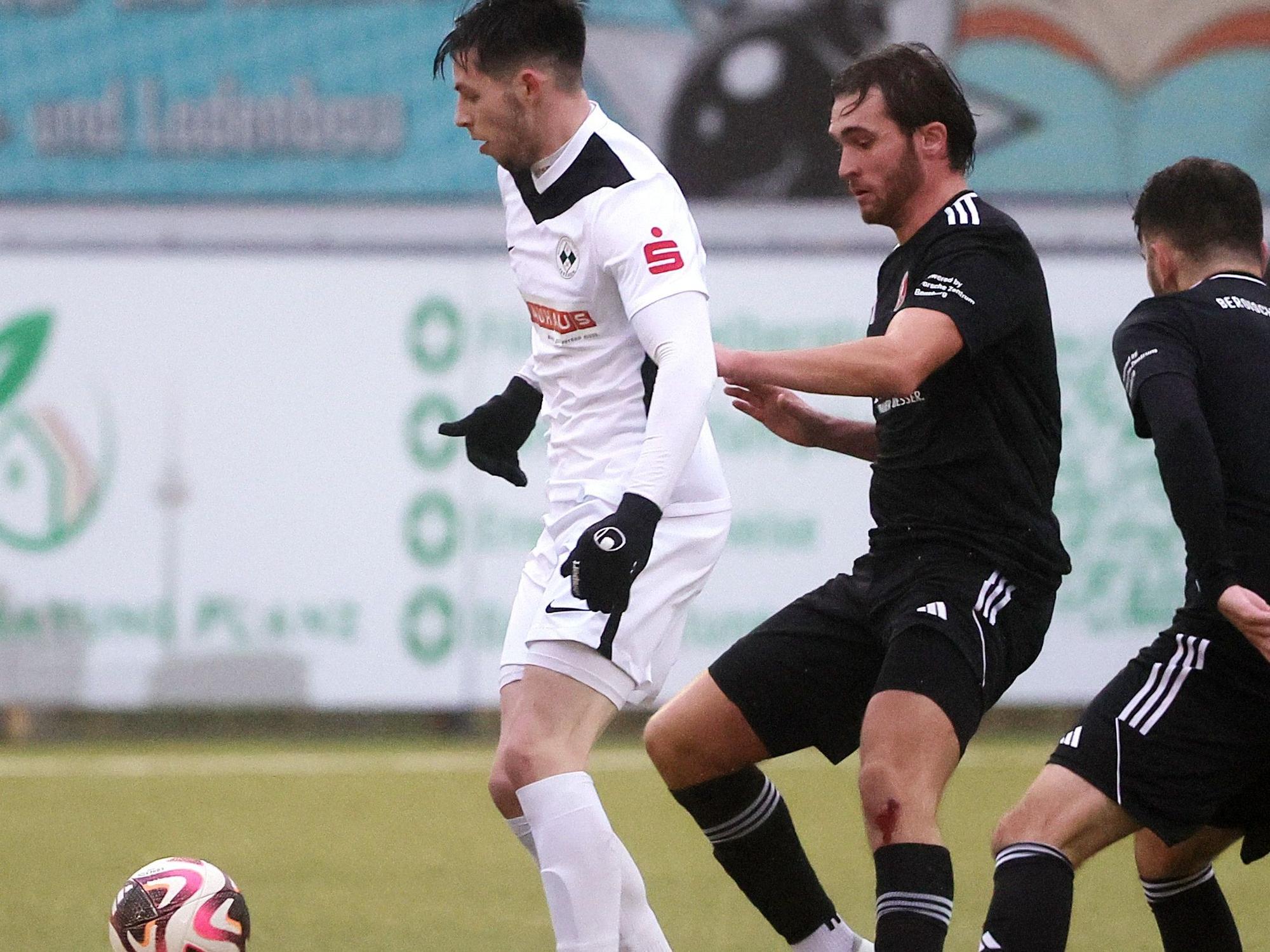 Das Bild zeigt Frechens Kai-Maxime Vranken (l.), der den Ball vor zwei Gegnern abschirmt.