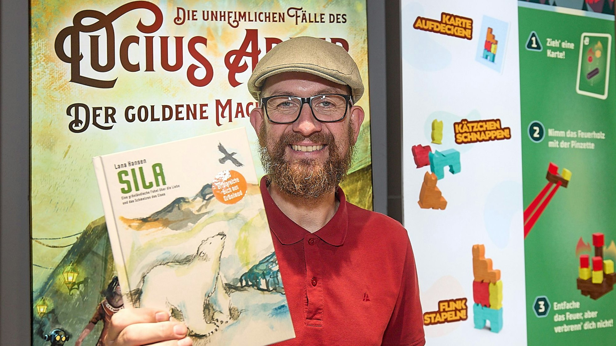 Der Verleger zeigt an seinem Stand das Buch mit dem Titel „Sila“.