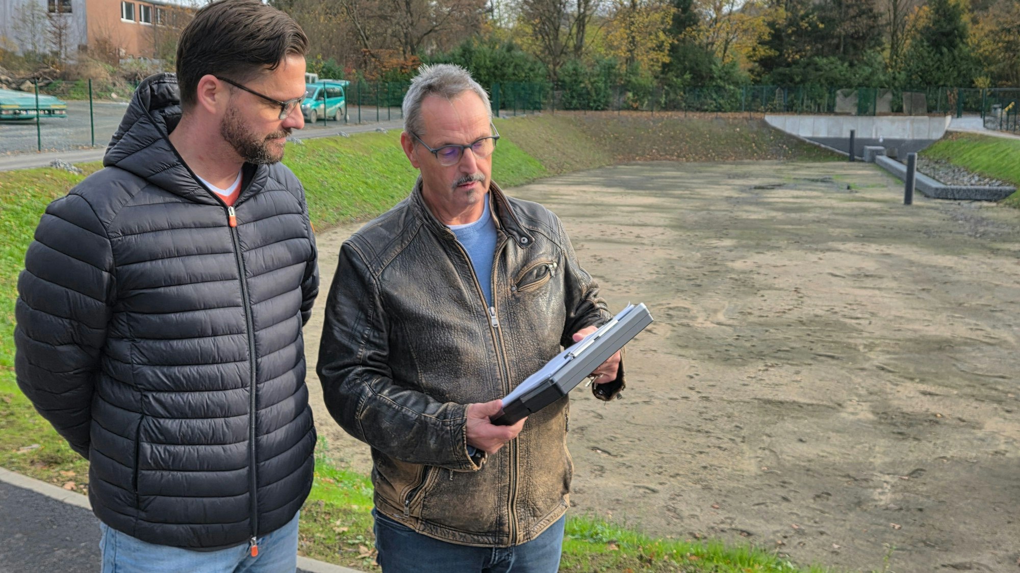 Nehmen in Waldbröl-Hermesdorf die restlichen Arbeiten am Retentionsbodenfilterbecken in den Blick: Stadtwerke-Geschäftsführer Mirco Kujbida (links) und Techniker Rüdiger Reifenrath.