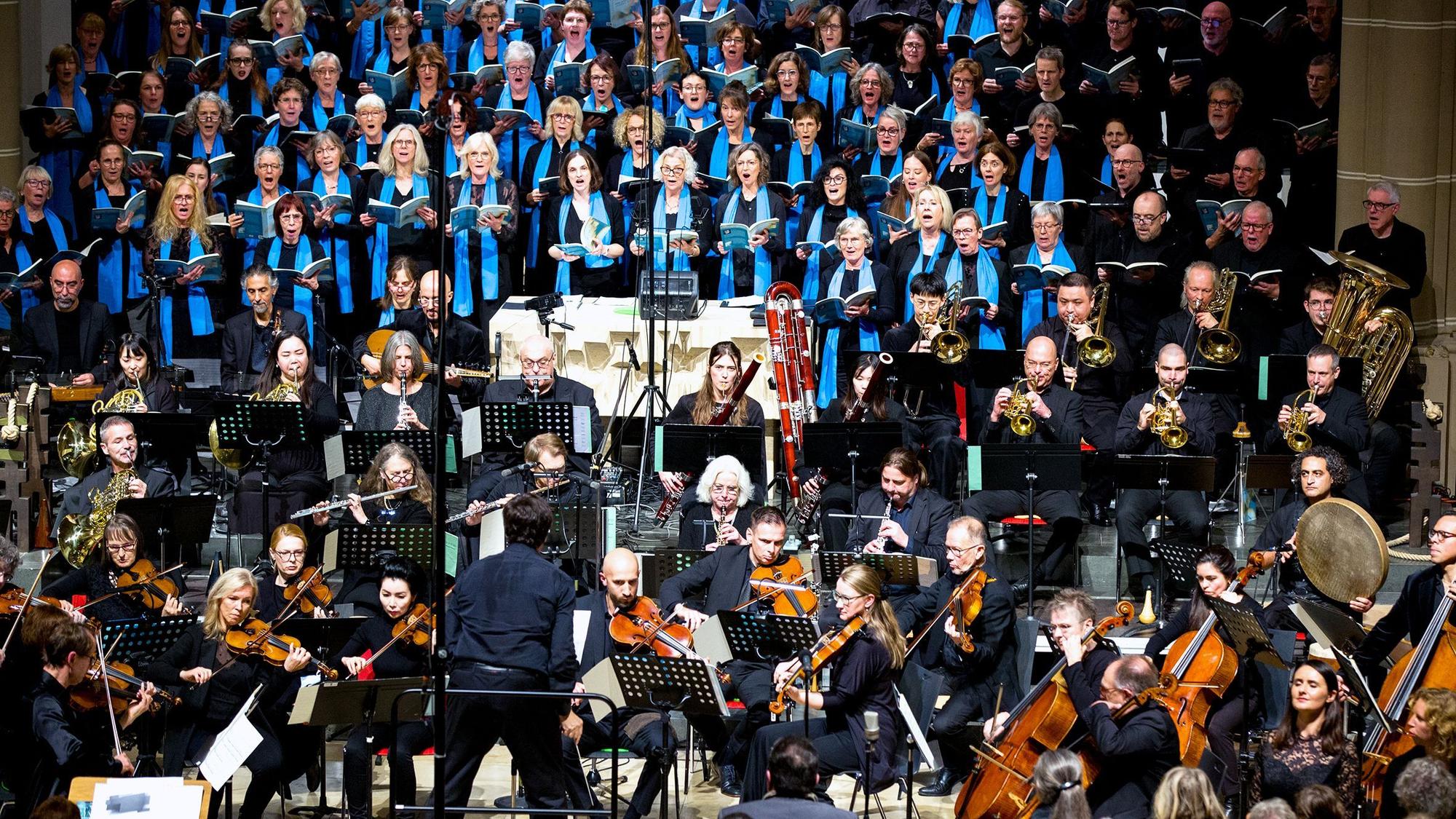 Ein Chor und Orchester sind im Altarraum einer Kirche aufgestellt.
