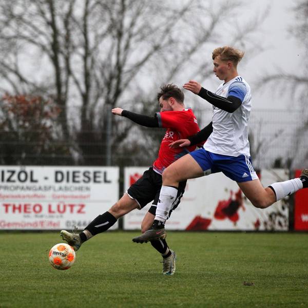 Ein Spieler des FC Dollendorf-Ripsdorf versucht mit einem Sprung an den Ball zu kommen, den ein Spieler von Dreiborn am Fuß hat.