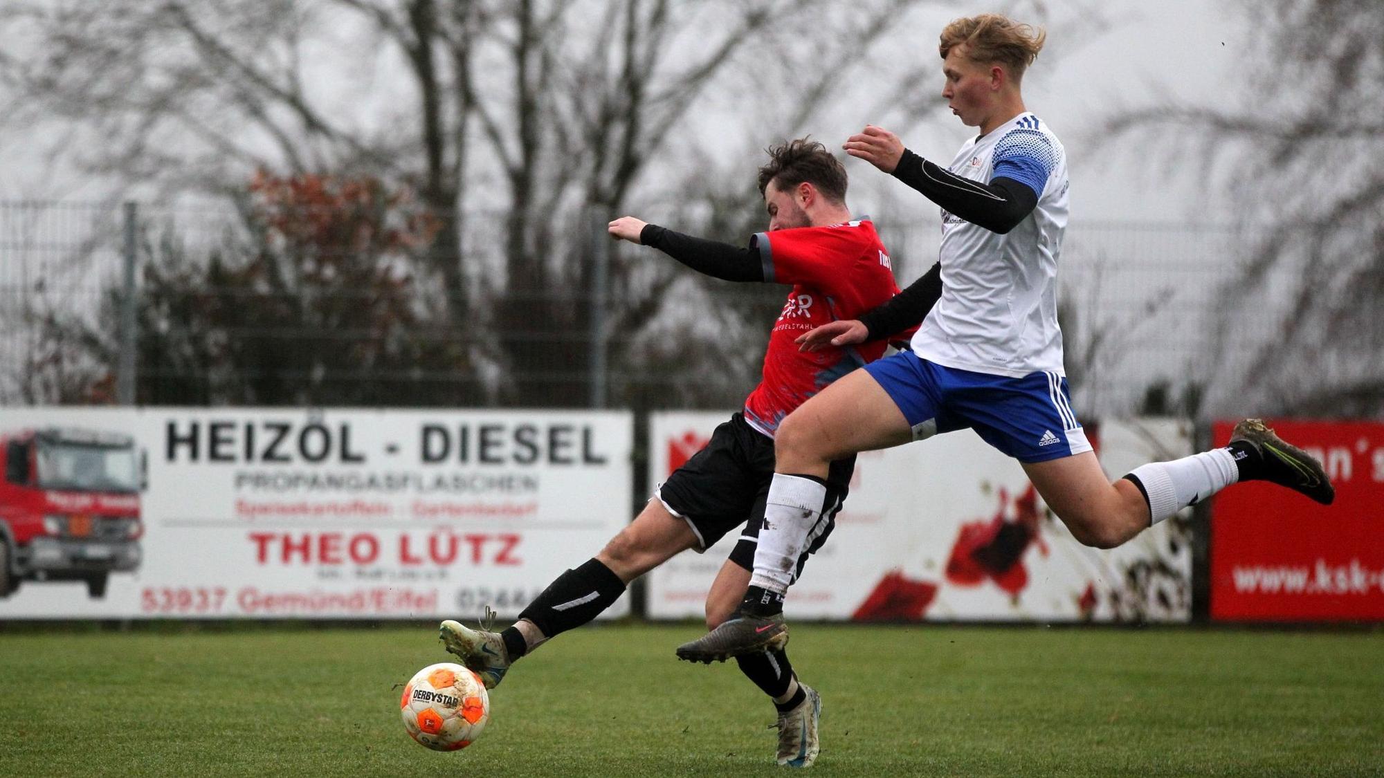 Ein Spieler des FC Dollendorf-Ripsdorf versucht mit einem Sprung an den Ball zu kommen, den ein Spieler von Dreiborn am Fuß hat.