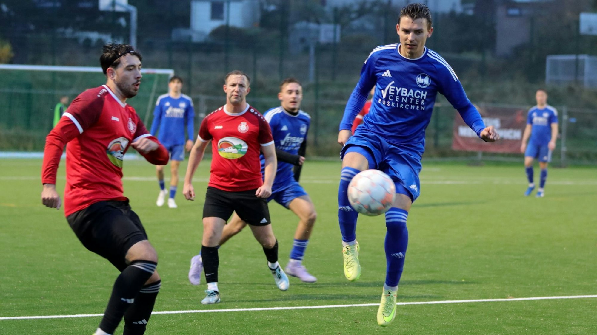 Mike Nandzik von Weilerswist springt in die Luft, der Ball ist vor ihm. Es ist nicht zu erkennen, ob er schießt oder den Ball annimmt. Ein Gegenspieler beobachtet ihn.
