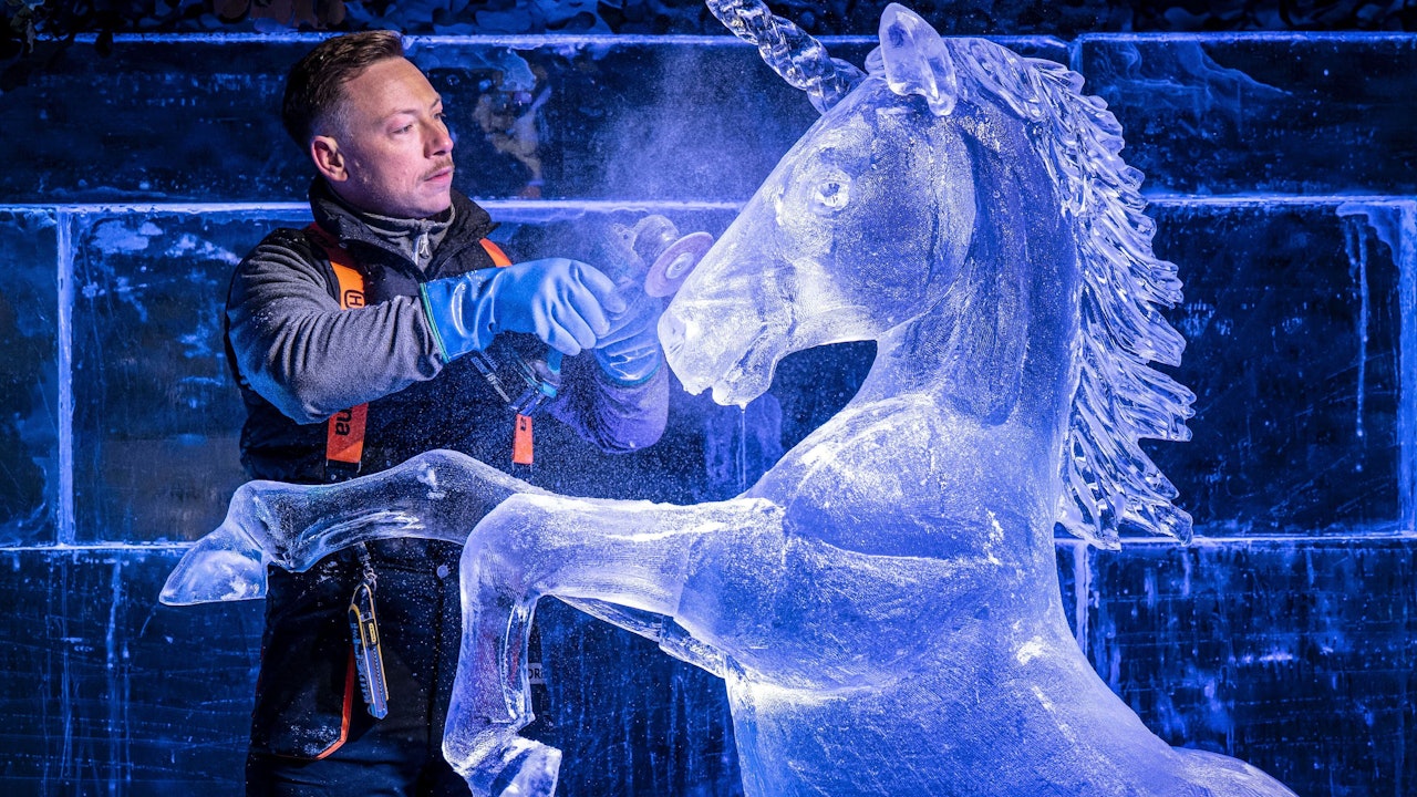 17.11.2025, Großbritannien, Edinburgh: Jack Hackney von Hamiltons Ice Sculptors legt letzte Hand an die Skulptur eines Einhorns für eine Eisbar auf dem Weihnachtsmarkt von Edinburgh.