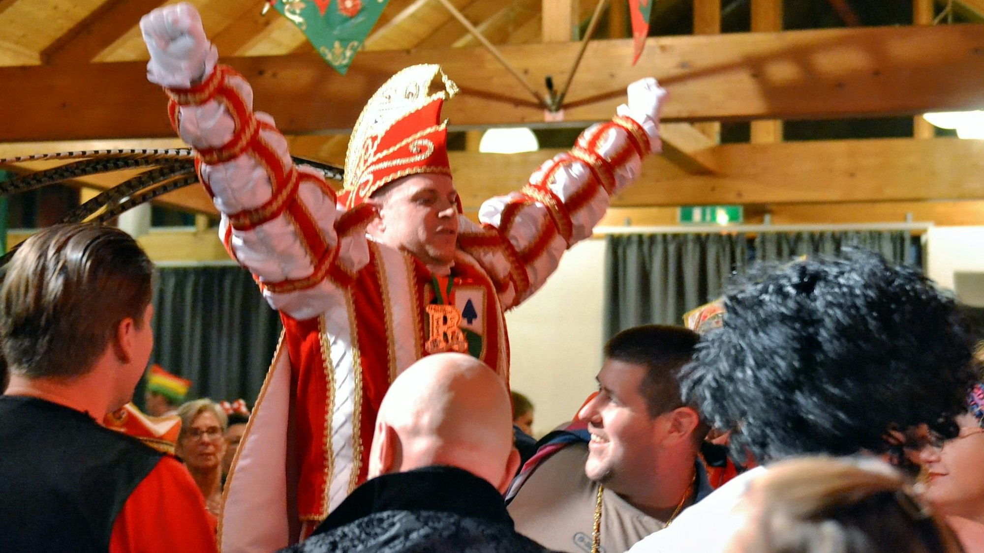 Karnevals-Prinz Marcel I. reißt die Arme beim Einmarsch in die Bürgerhalle jubelnd nach oben.