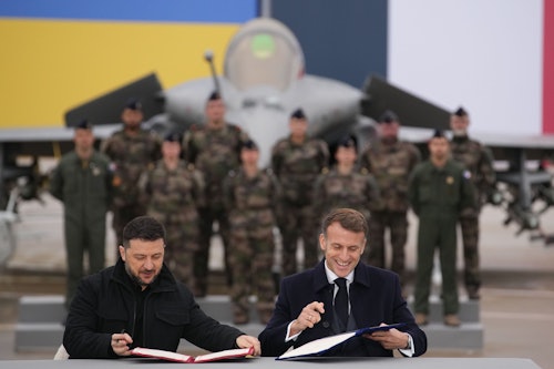 17.11.2025, Frankreich, Villacoublay: Der französische Präsident Emmanuel Macron (r) und der ukrainische Präsident Wolodymyr Selenskyj unterzeichnen auf dem Luftwaffenstützpunkt Villacoublay bei Paris ein Abkommen.