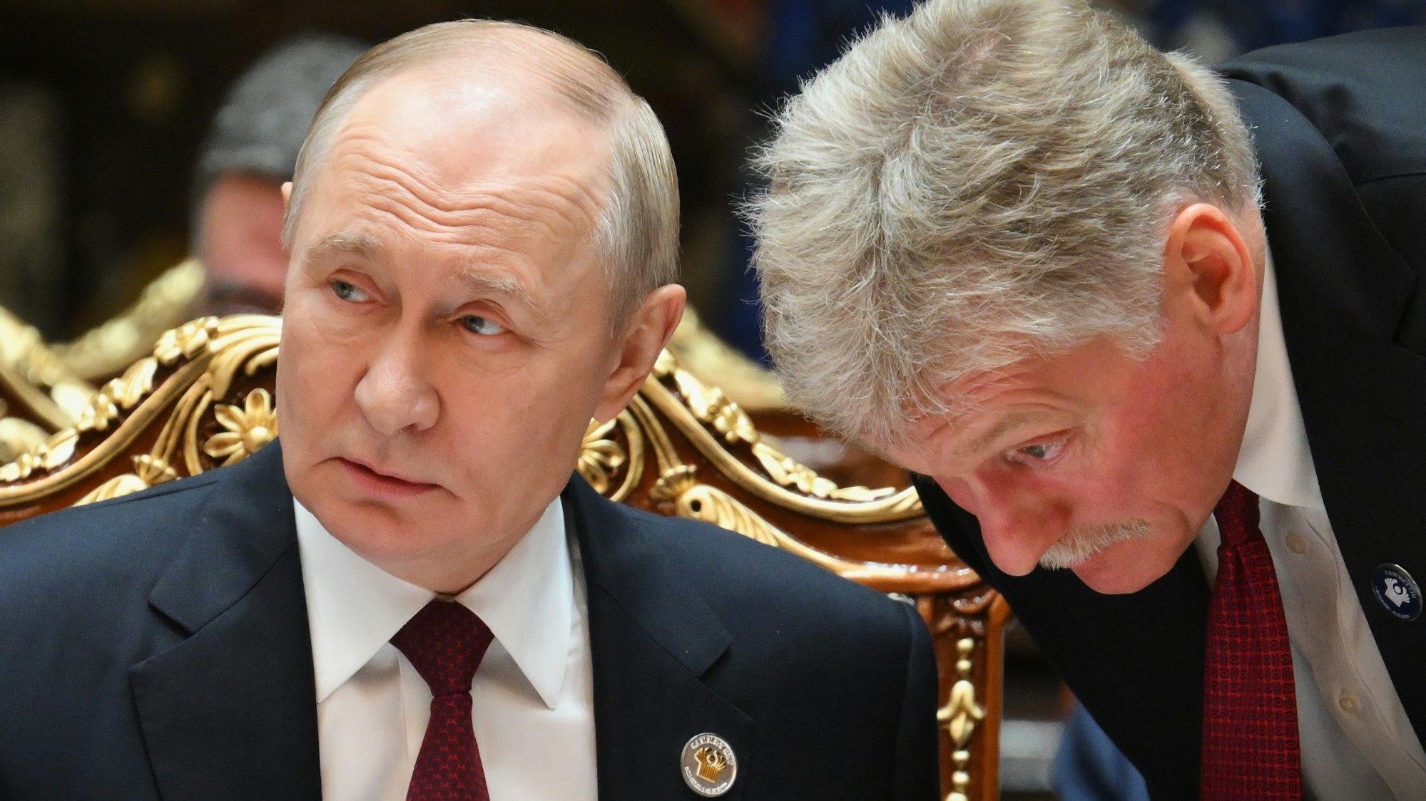 Kremlchef Wladimir Putin (l) spricht während des Gipfels im Palast der Nation mit seinem Sprecher Dmitri Peskow. (Archivbild)