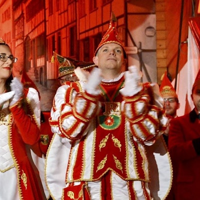 Prinzessin Michaela I. und Prinz Marcel I. stehen im Tollitäten-Ornat klatschend auf der Bühne der Kommerner Bürgerhalle.