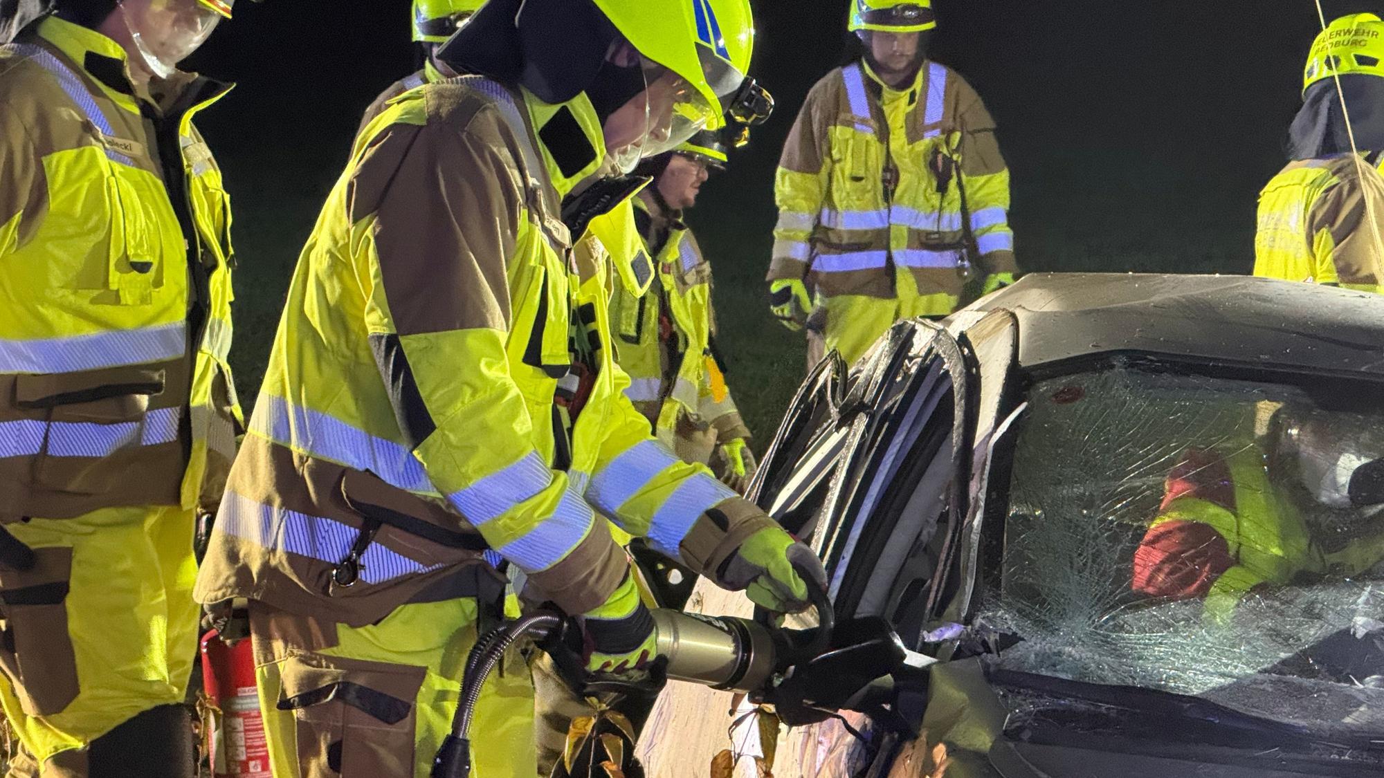 Das Bild zeigt einen verunglückten Pkw mit mehreren Einsatzkräften der Feuerwehr.