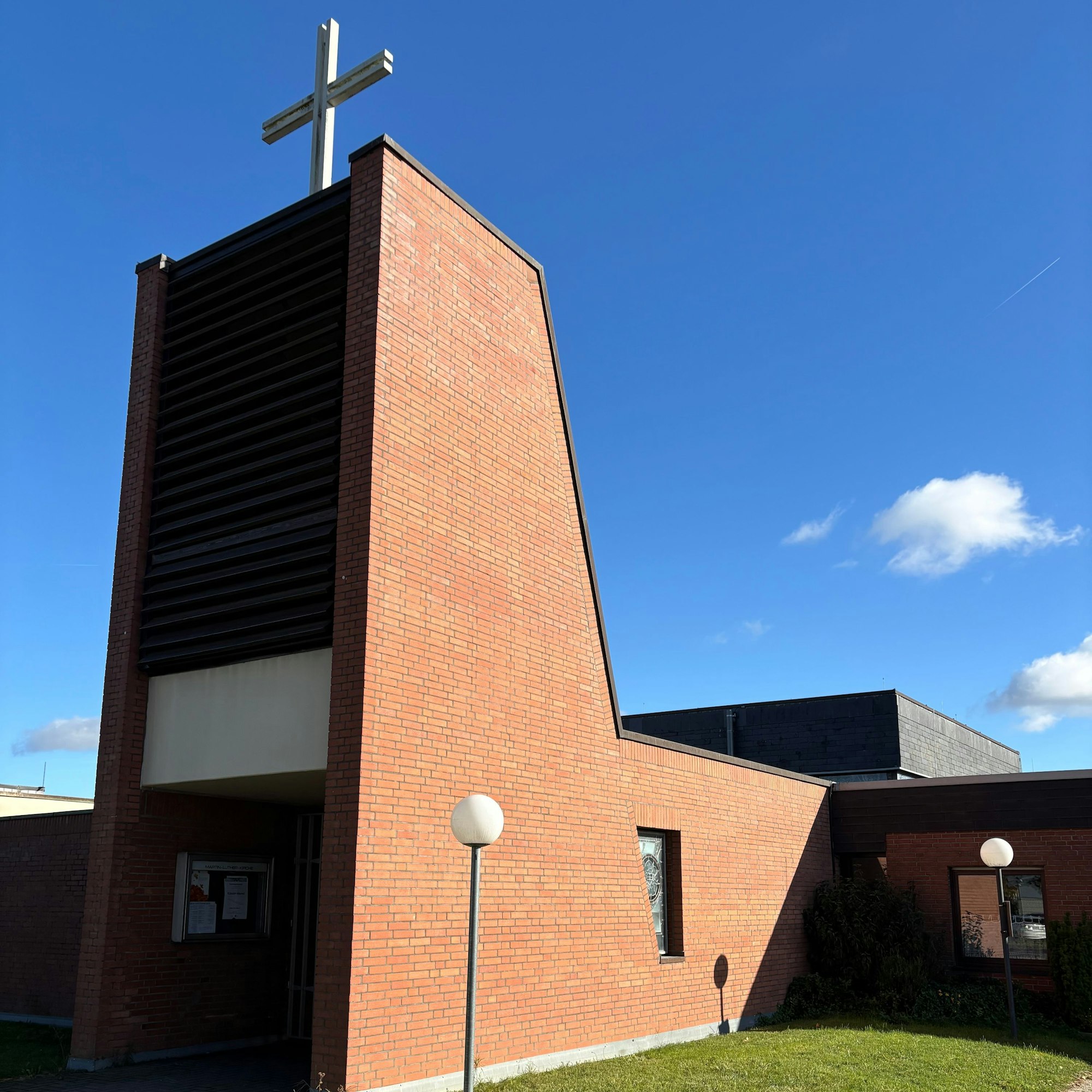 Die Martin-Luther-Kirche wird von der Sonne angestrahlt. Am Eingangsbereich des Gebäudes wird ein Schatten geworfen.