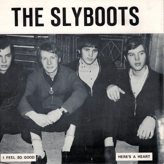 Die Vier Bandmitglieder sitzen am Boden.