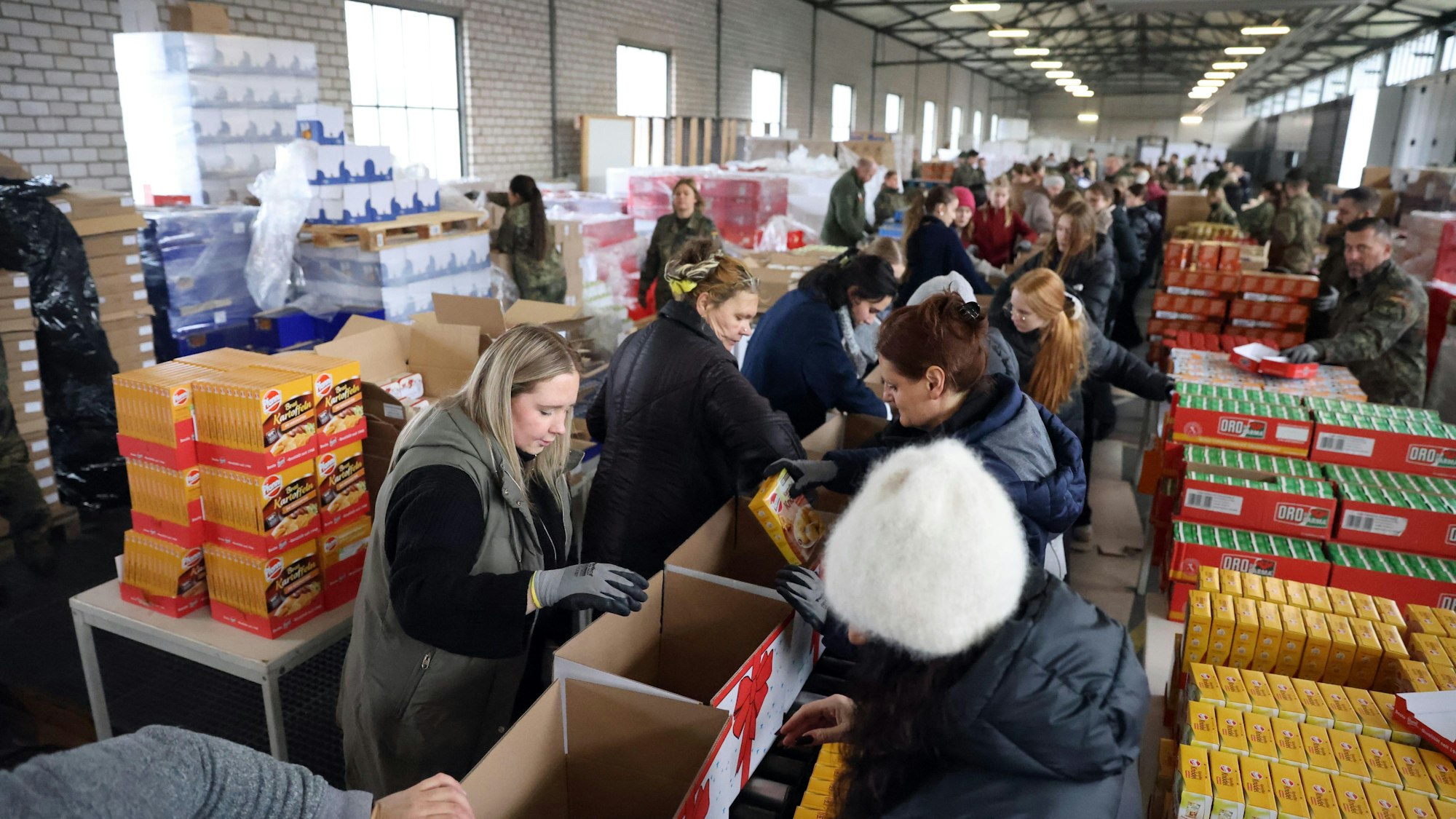 Am Fließband packen Helferinnen und Helfer die Weihnachtspakete der Rundschau-Altenhilfe.