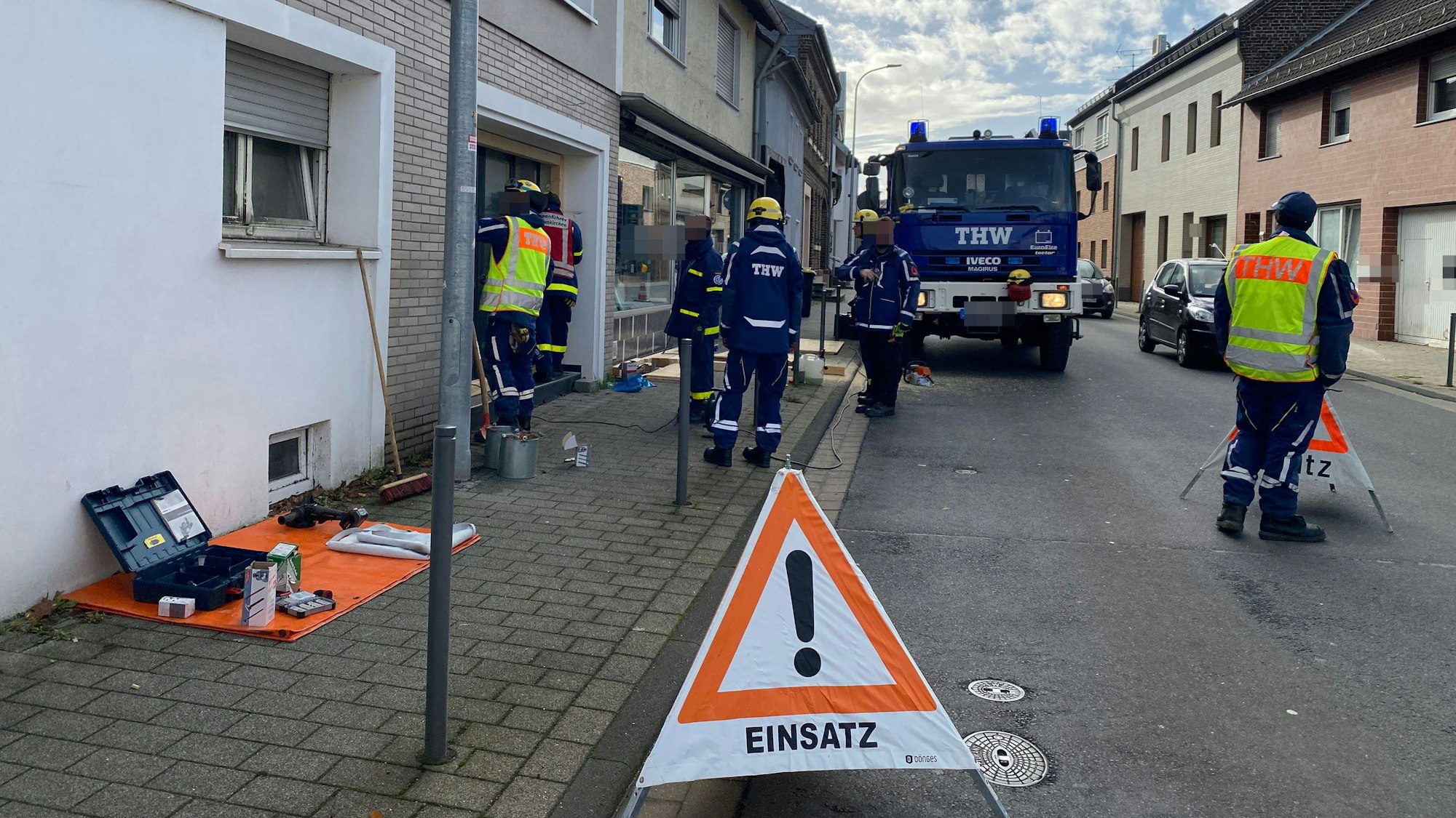Die Einsatzkräfte des THW stehen vor dem Haus, in dem die Drogenplantage gefunden wurde.