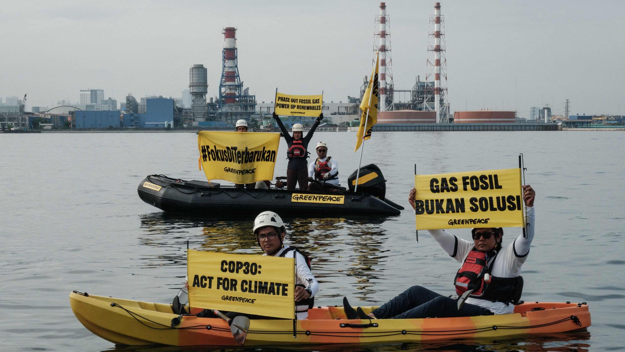 Das Bild zeigt Greenpeace-Aktivisten bei einer Protestaktion am Rande der COP30-Klimakonferenz im brasilianischen Belem. Foto: Yasuyoshi Chiba/AFP
