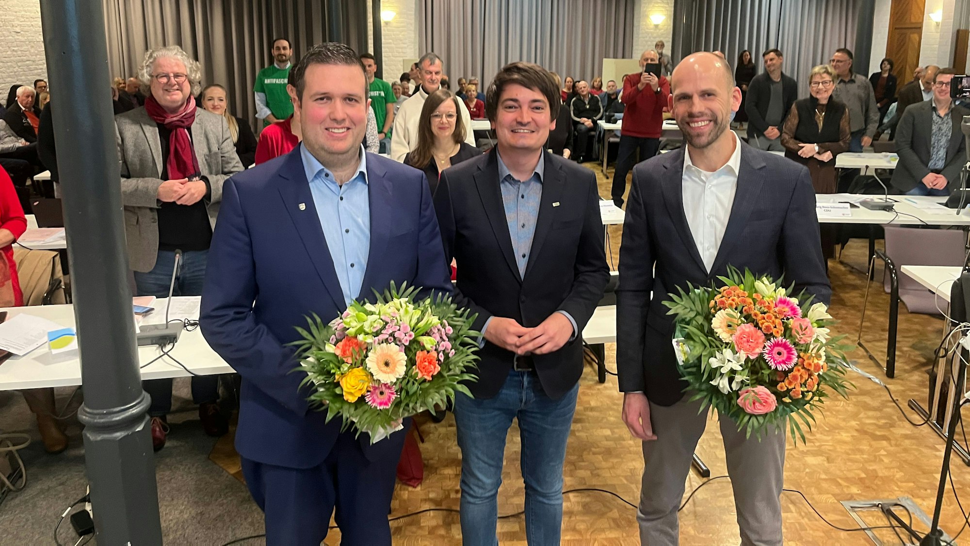 Bürgermeister Mario Dahm (M.) steht mit dem 1. stellvertretenden Bürgermeister Max Heller (CDU, r.) und dem 2. stellvertretenden Bürgermeister Oliver Brock (SPD, l.) vor dem Stadtrat in der Meys Fabrik.