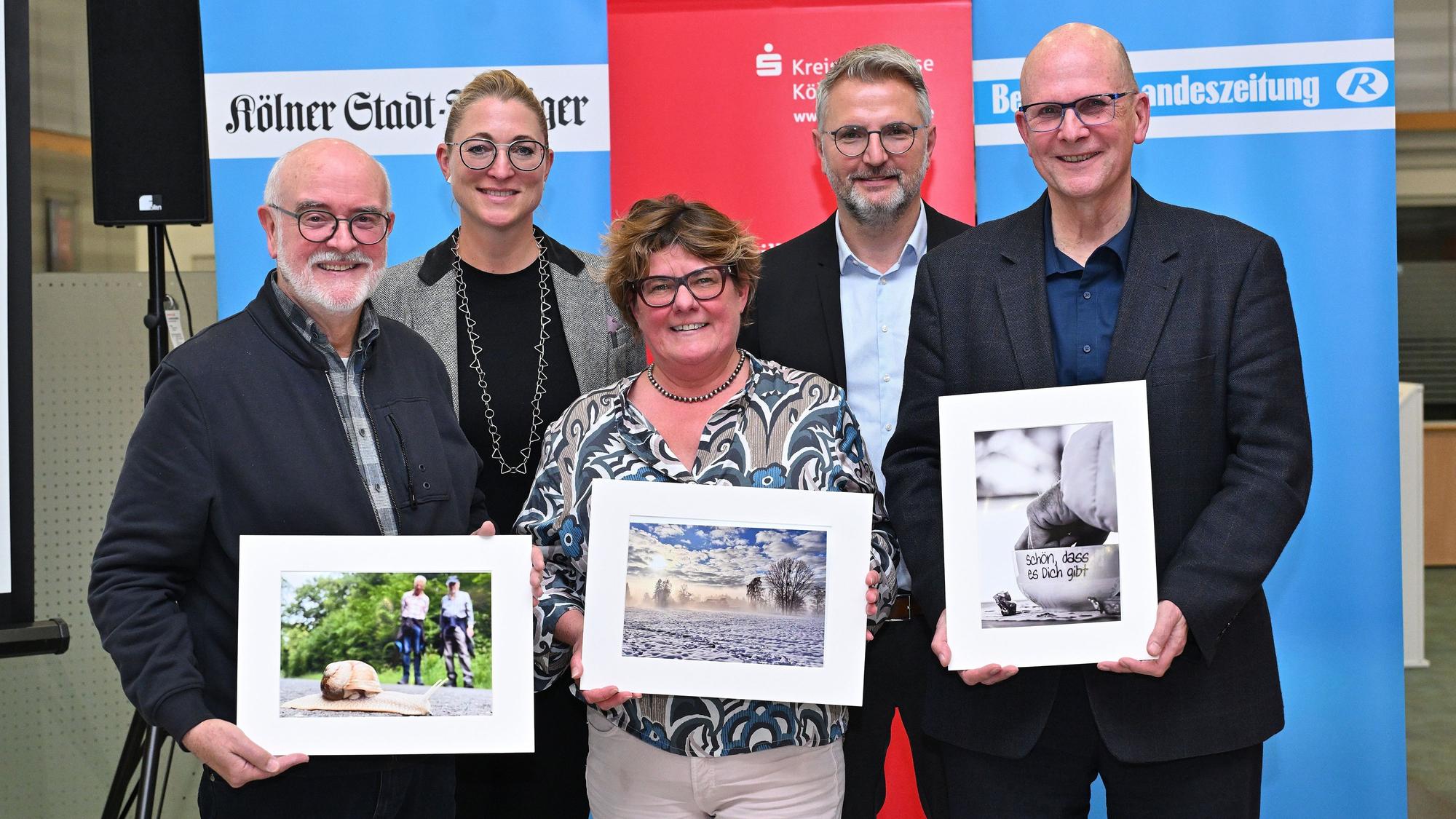 Die Preisträger Wolfgang Müller, Andreas Heine und Frauke Reichel halten ihre Siegerfotos in den Händen.