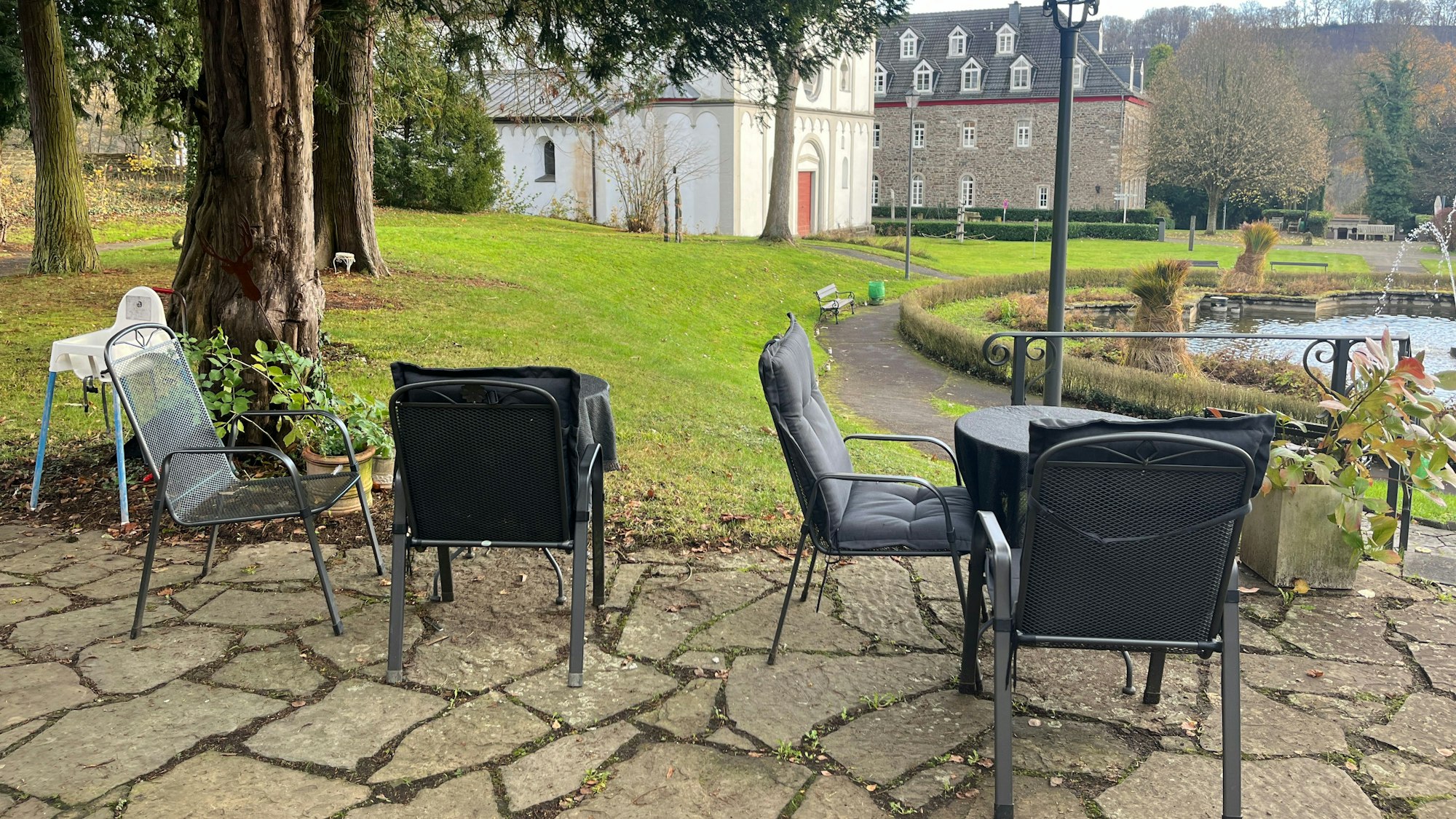 Der Blick von der Terrasse geht in den Schlosspark, auf Springbrunnen, alte Klostergebäude und die Kirche St. Agnes.
