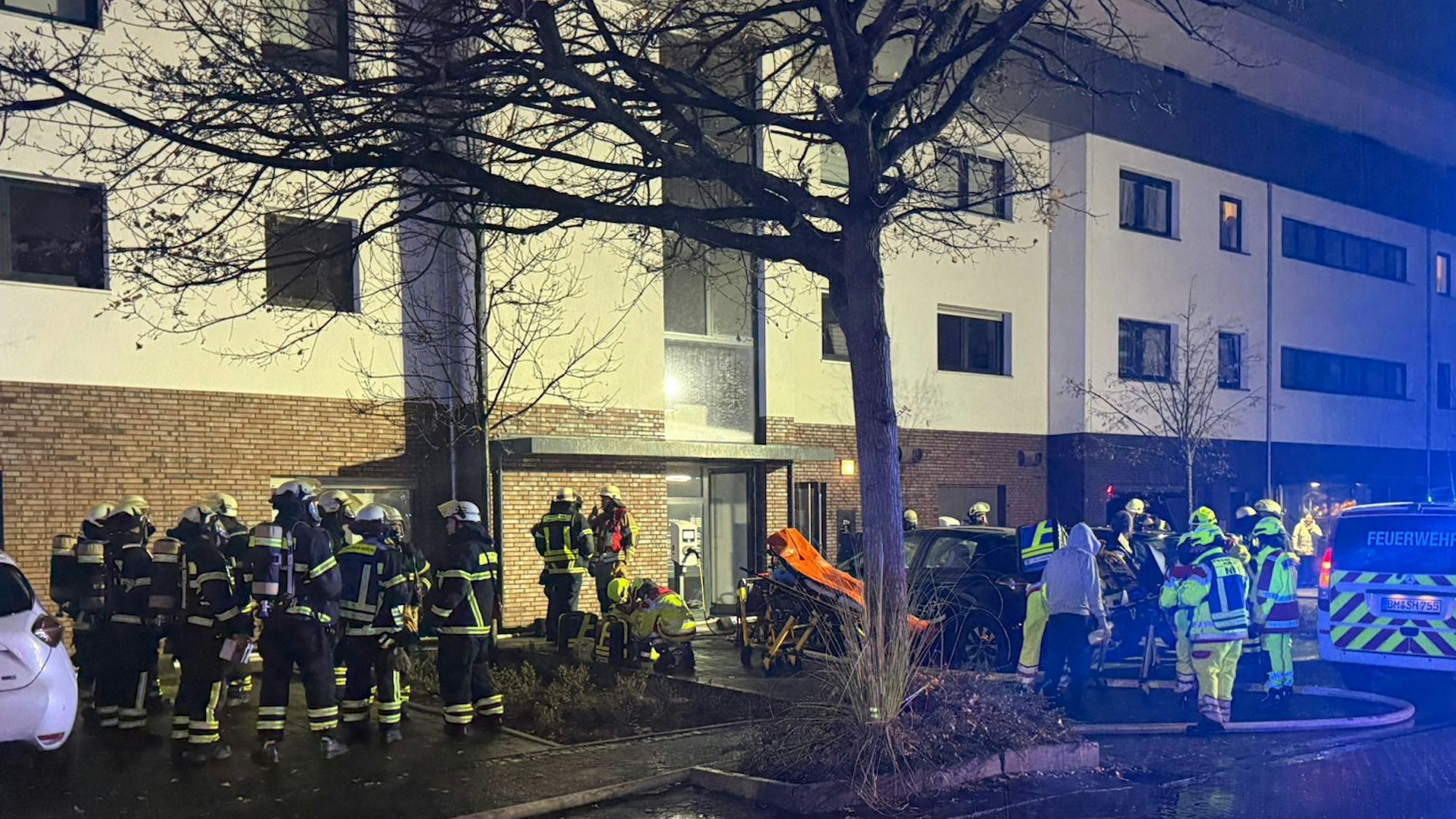 Das Bild zeigt Einsatzkräfte der Feuerwehr vor einem Wohnhaus.