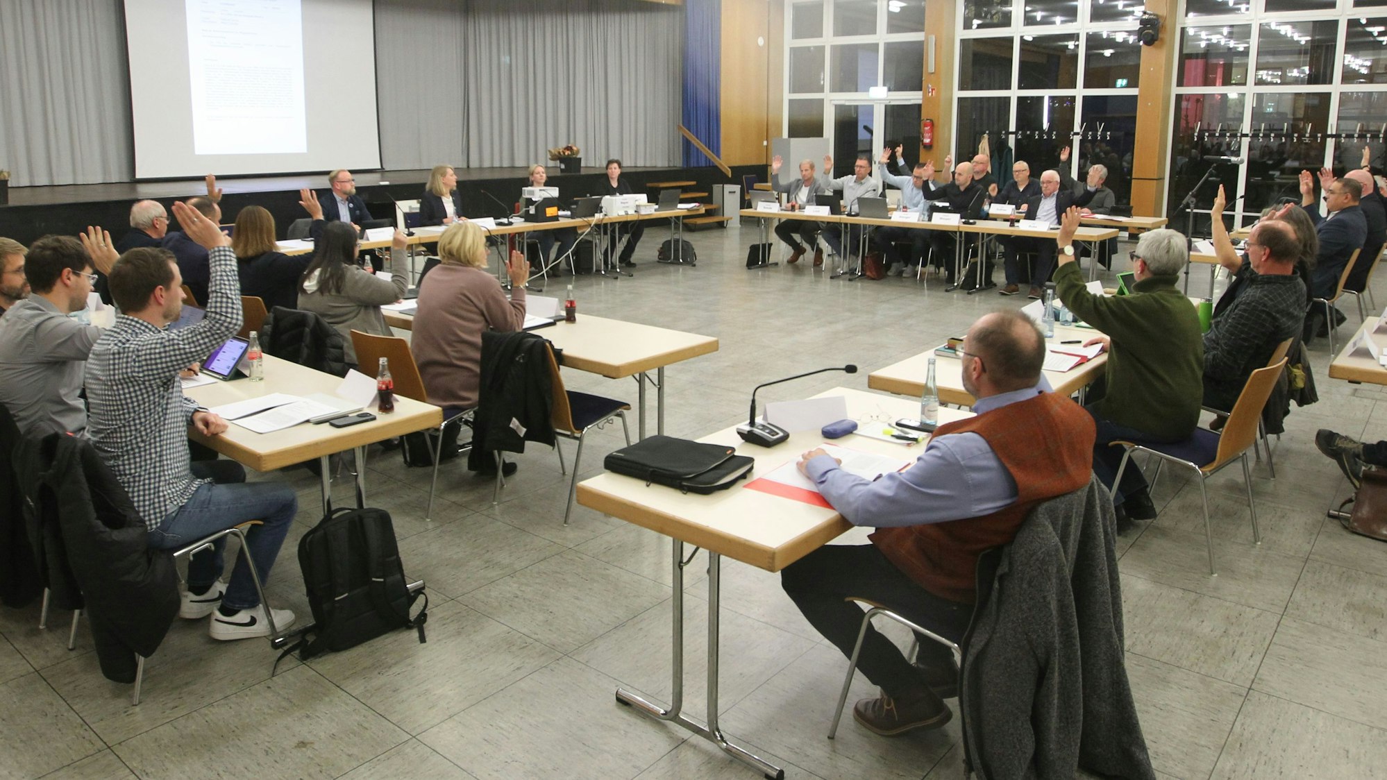 Mitglieder eines Gemeinderats bei einer Abstimmung.