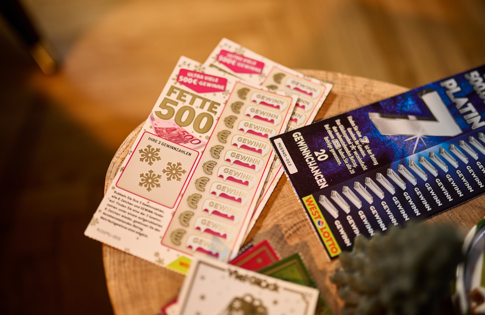 Verschiedene Rubbellose von WestLotto liegen auf einem Holztisch.
