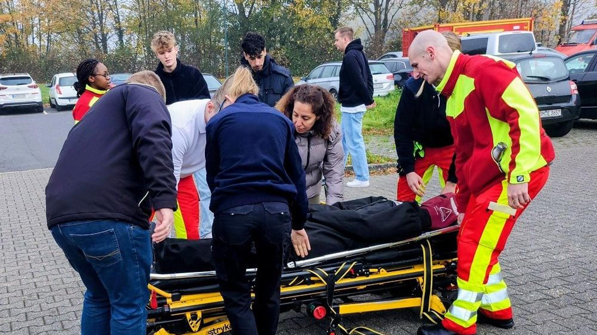 Das Foto zeigt Menschen, die einen Dummy auf einer Liege transportieren.