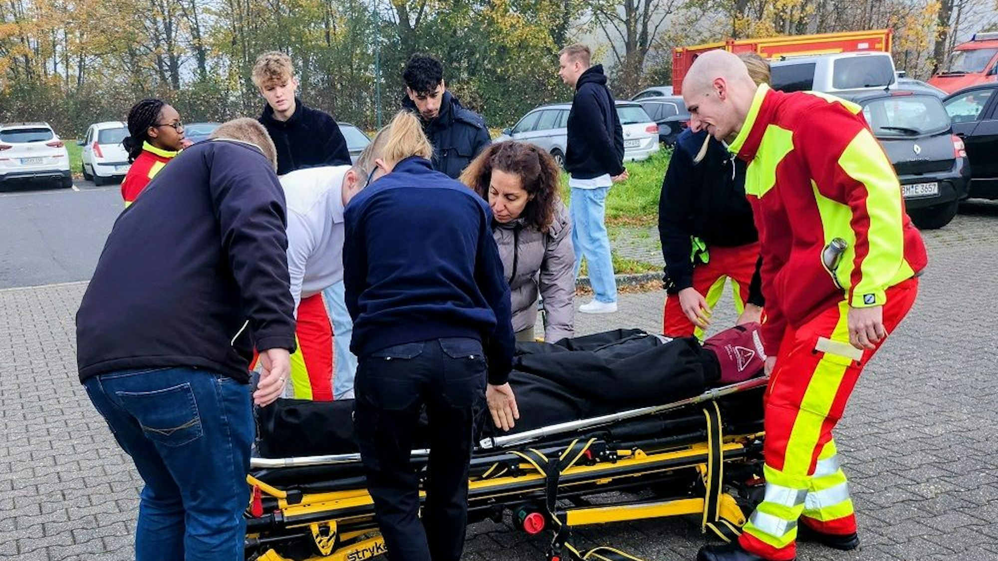 Das Foto zeigt Menschen, die einen Dummy auf einer Liege transportieren.